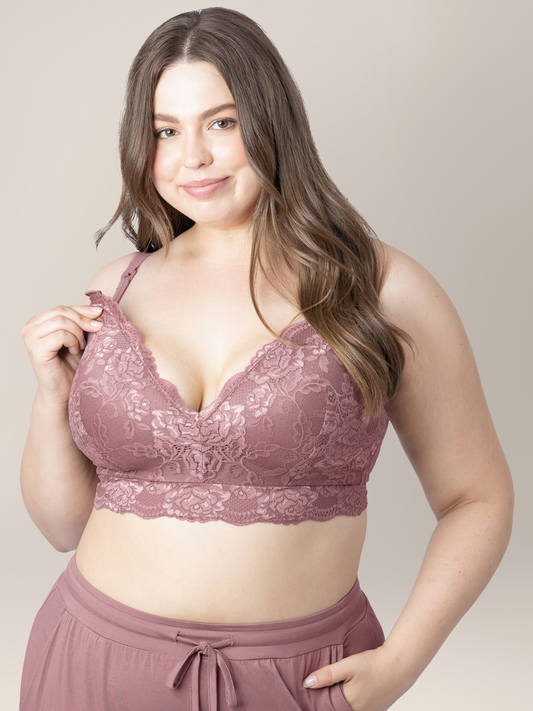 Model looking at the camera while holding the easy clip down nursing access clip on the Lace Minimalist Nursing & Maternity Bra in Twilight @model_info:Bailey is wearing an X-Large Busty.