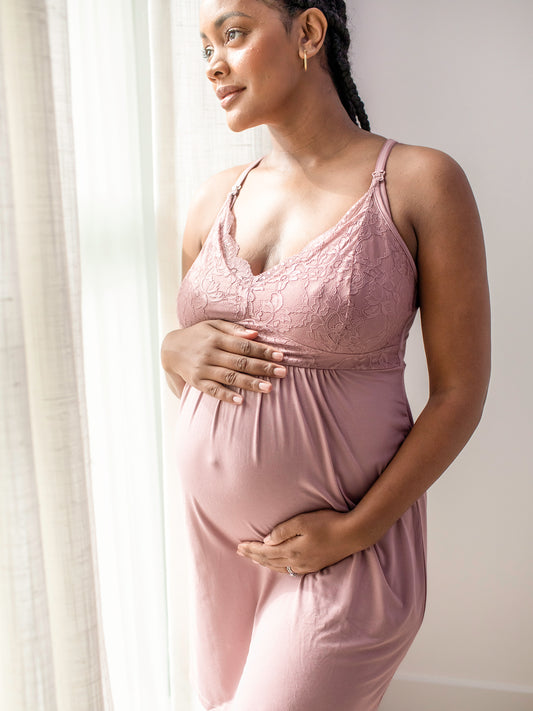 Model wearing the Lucille Maternity & Nursing Nightgown in Vintage pink holding her pregnant belly. @model_info:Roxanne is 5'8" and wearing a Large.