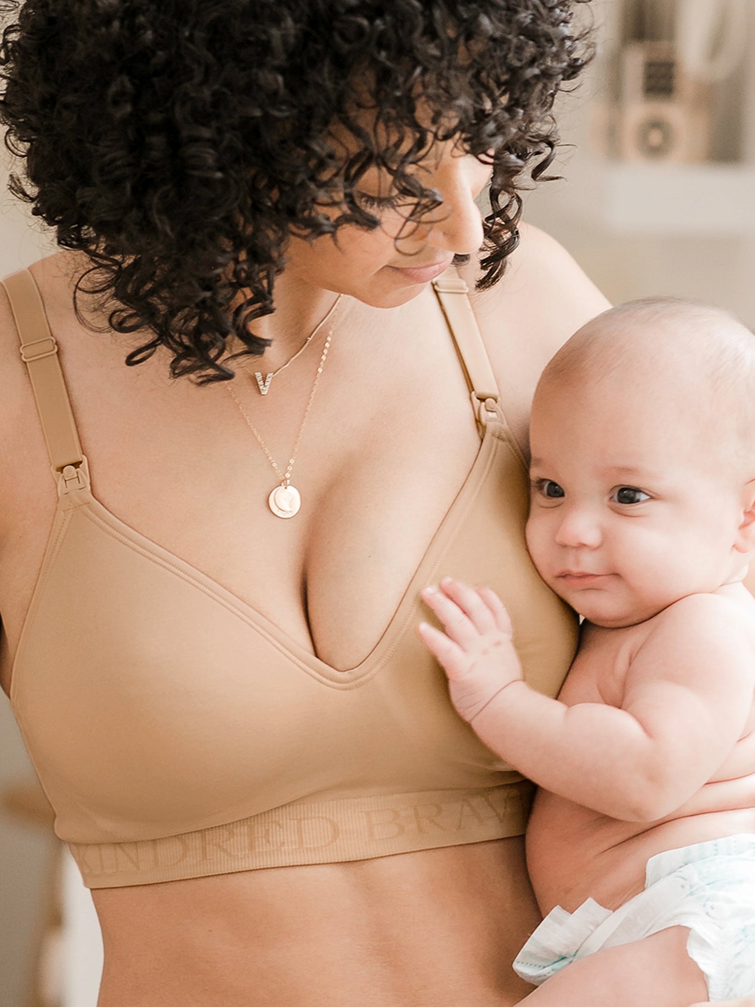 Model holding her baby while wearing the Signature Sublime Contour Nursing & Maternity Bra in Beige. @model_info:Arion is wearing a Small Regular.