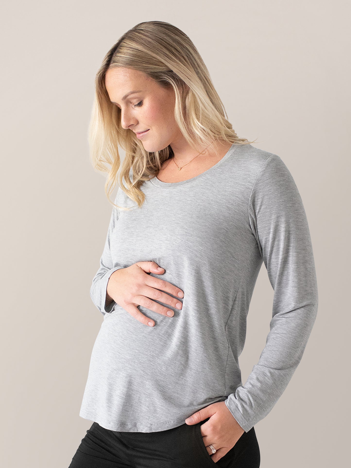 Pregnant model wearing the Bamboo Maternity & Nursing Long Sleeve T-shirt in Grey Heather with her hand on her stomach. 