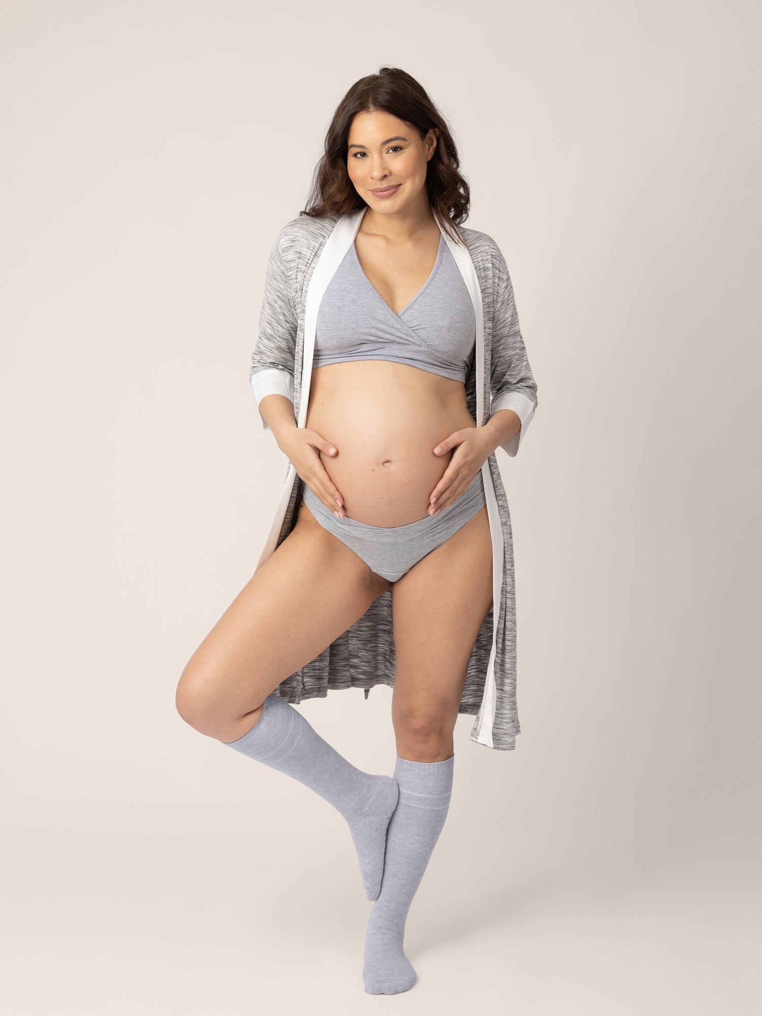 Pregnant model wearing the Premium Maternity Compression Socks in Grey Heather holding her belly.