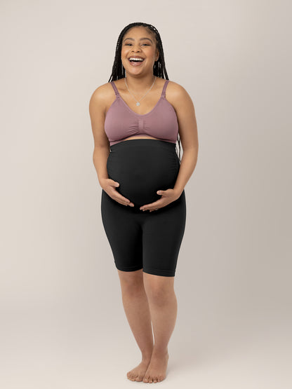 Pregnant model wearing the Seamless Bamboo Maternity Thigh Savers in Black holding her belly. @model_info:Ruby is wearing a Medium.