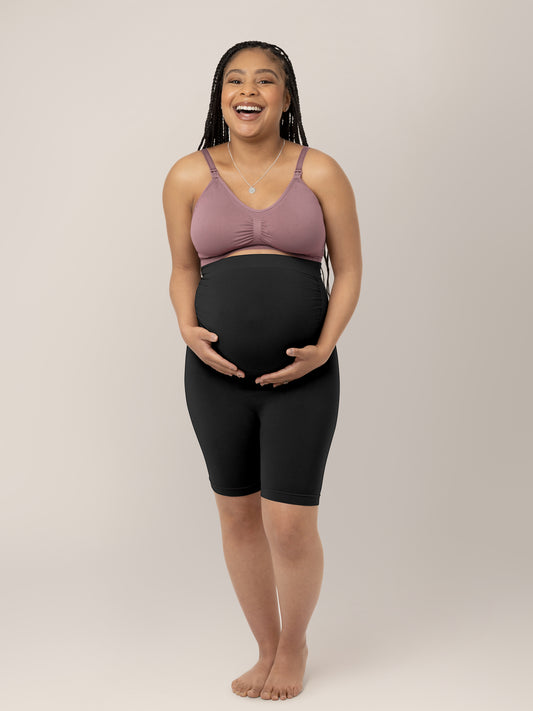 Pregnant model wearing the Seamless Bamboo Maternity Thigh Savers in Black holding her belly. @model_info:Ruby is wearing a Medium.
