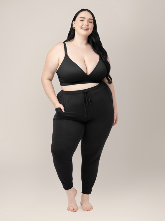 Model wearing the Minimalist Maternity & Nursing Bra in Black with her hand in her pocket. 