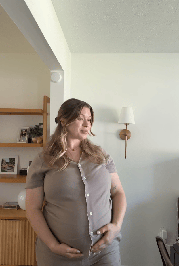 Looping gif of pregnant woman enjoying her baby bump in the Cotton Bamboo Pajama Set in Taupe, in her living room.