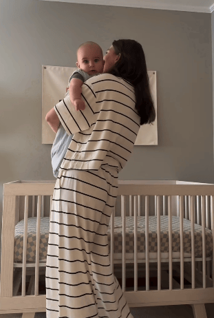 Short video clip of a mother holding a baby in nursery and smiling while wearing Aria Bamboo Casual Lounge Pant in White & Black Stripe and Aria Bamboo Casual Cropped Short Sleeve Top in White & Black Stripe.