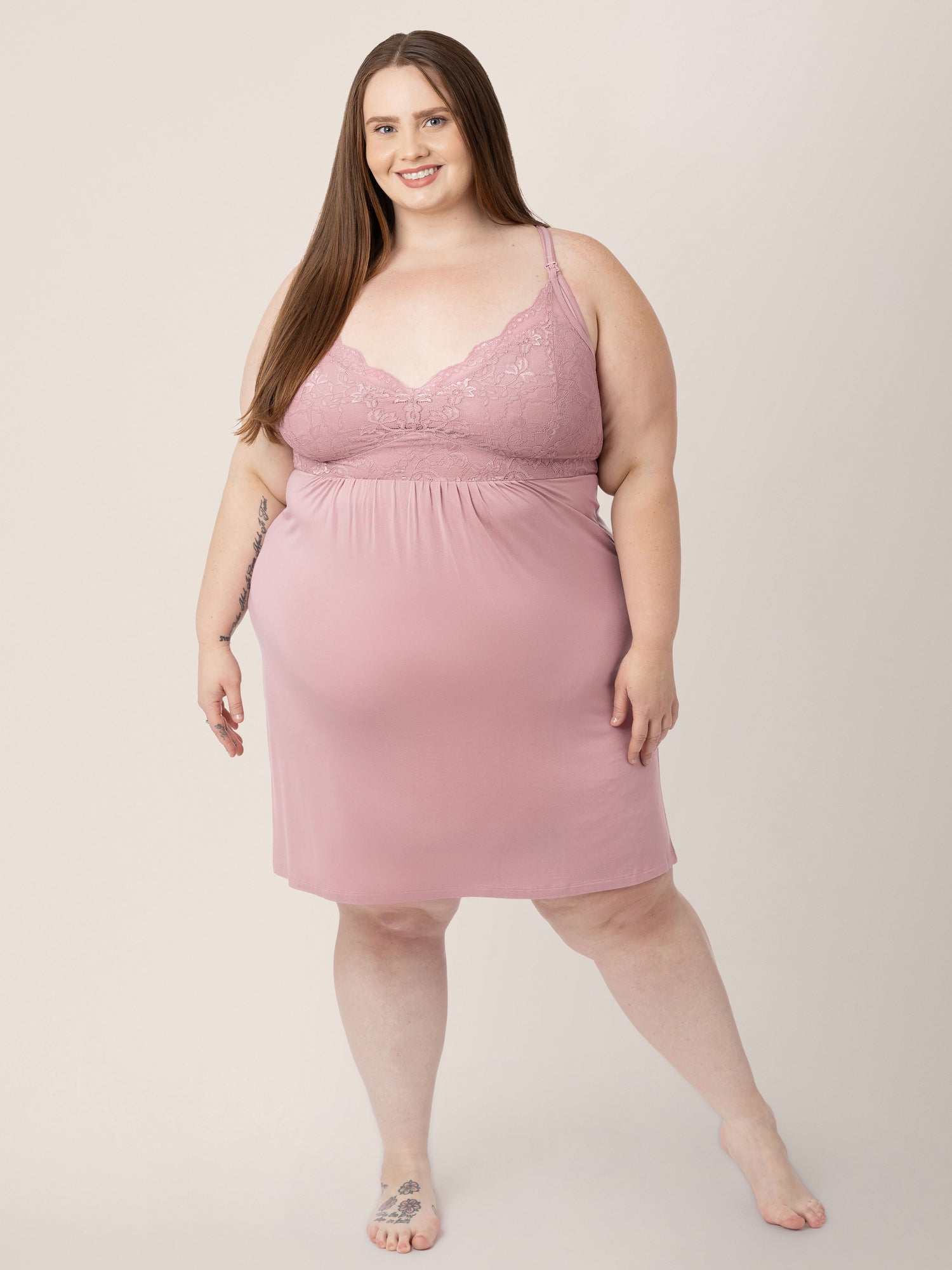 Model standing with her weight more on one leg than the other with her hands at her side while wearing the Lucille Maternity & Nursing Nightgown in Vintage Pink. 