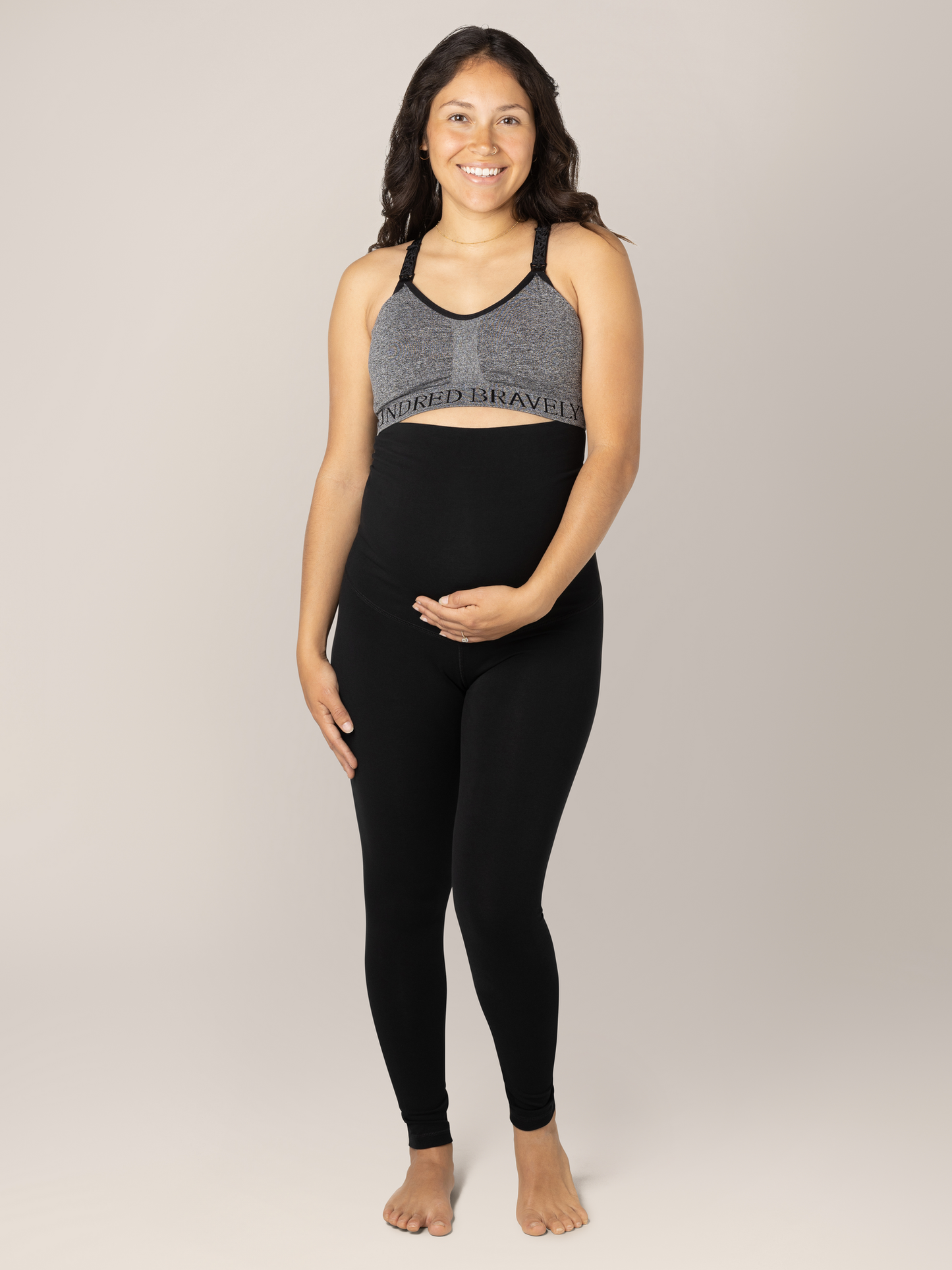 Front view of pregnant model wearing the Cotton Maternity & Postpartum Footless Tight in black, with Sublime® Nursing Sports Bra in heather grey