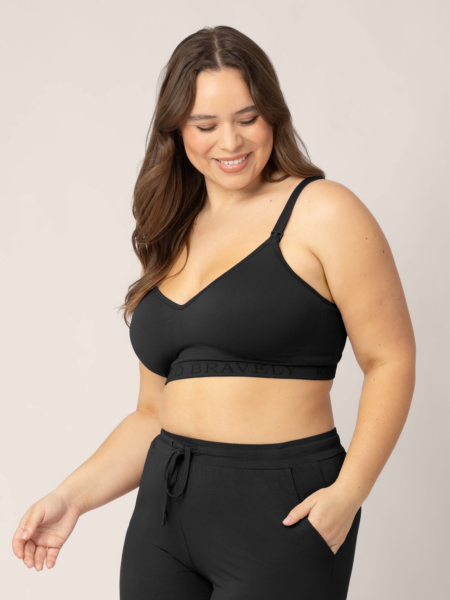 Busty model wearing the Signature Sublime® Contour Maternity & Nursing Bra in Black with one hand in her pocket. 