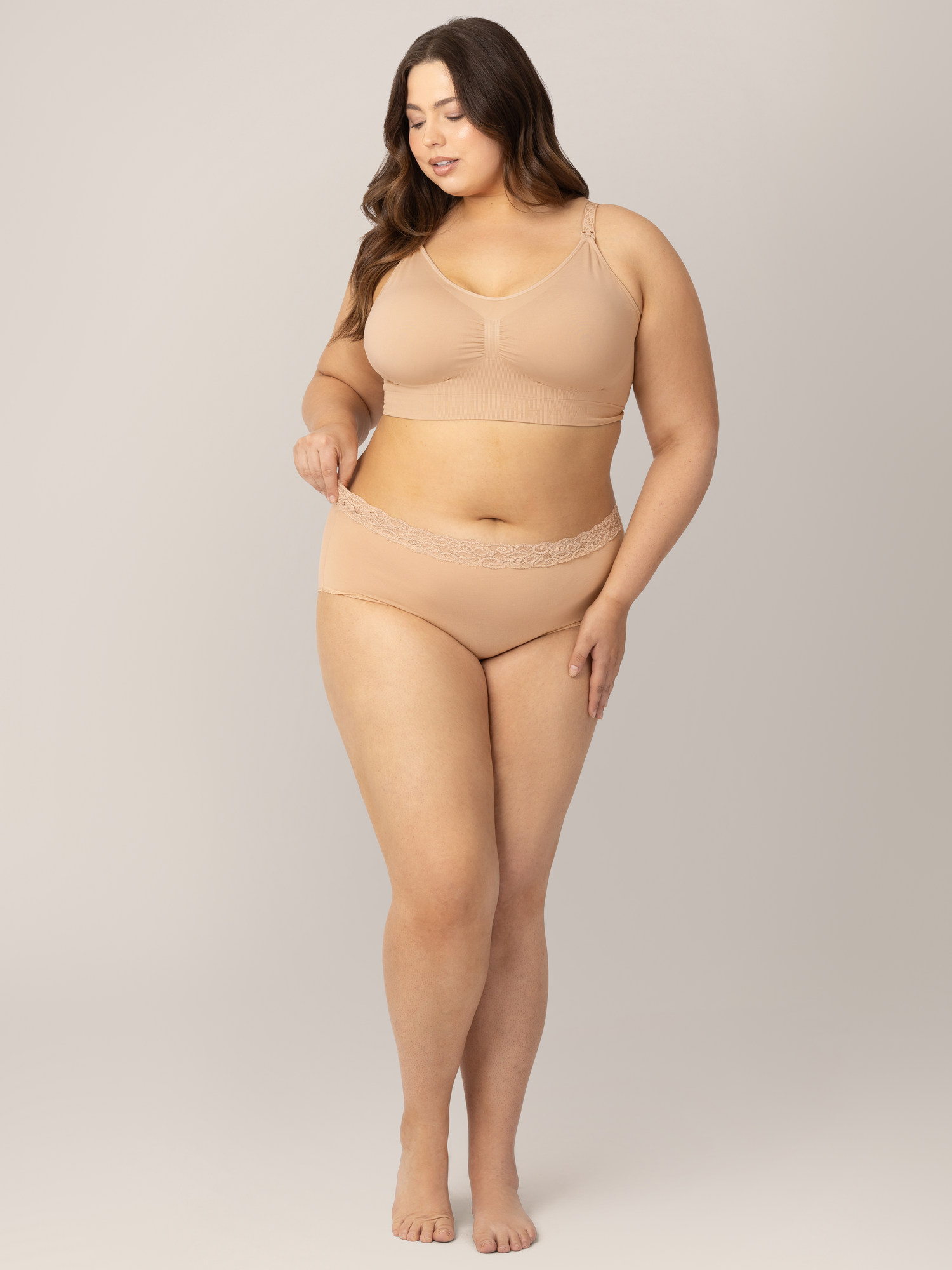 Model wearing the High-Waisted Postpartum Underwear in Assorted Neutrals with her hand holding onto the waistband.
