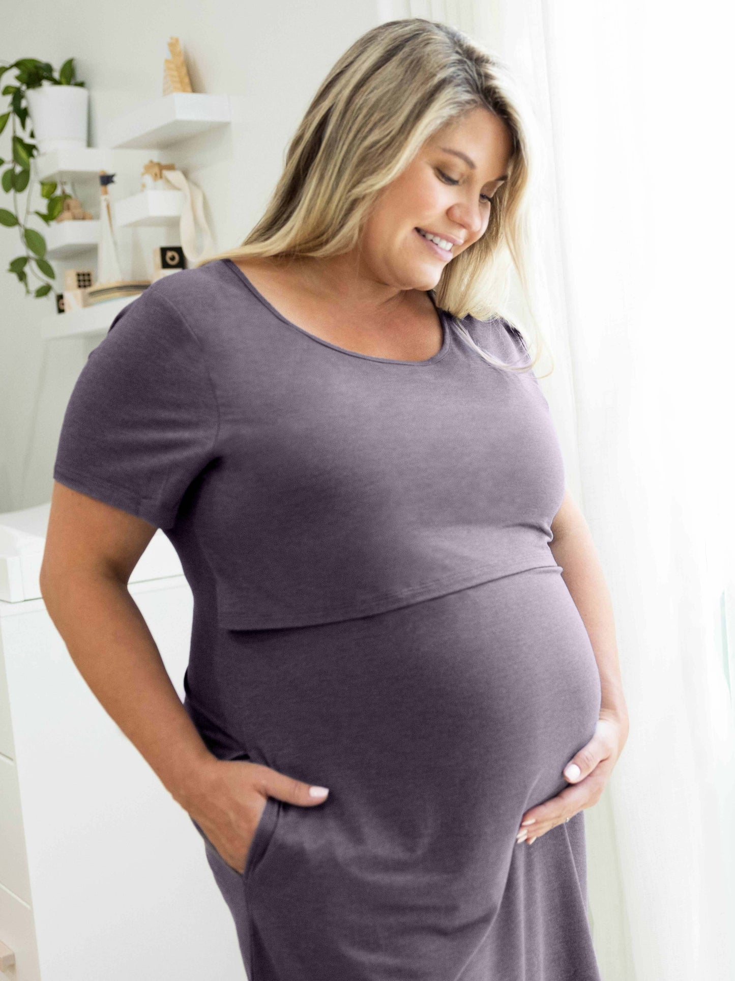 Model holding her pregnant belly while wearing the Eleanora Bamboo Maternity & Nursing Dress in Heathered Granite.