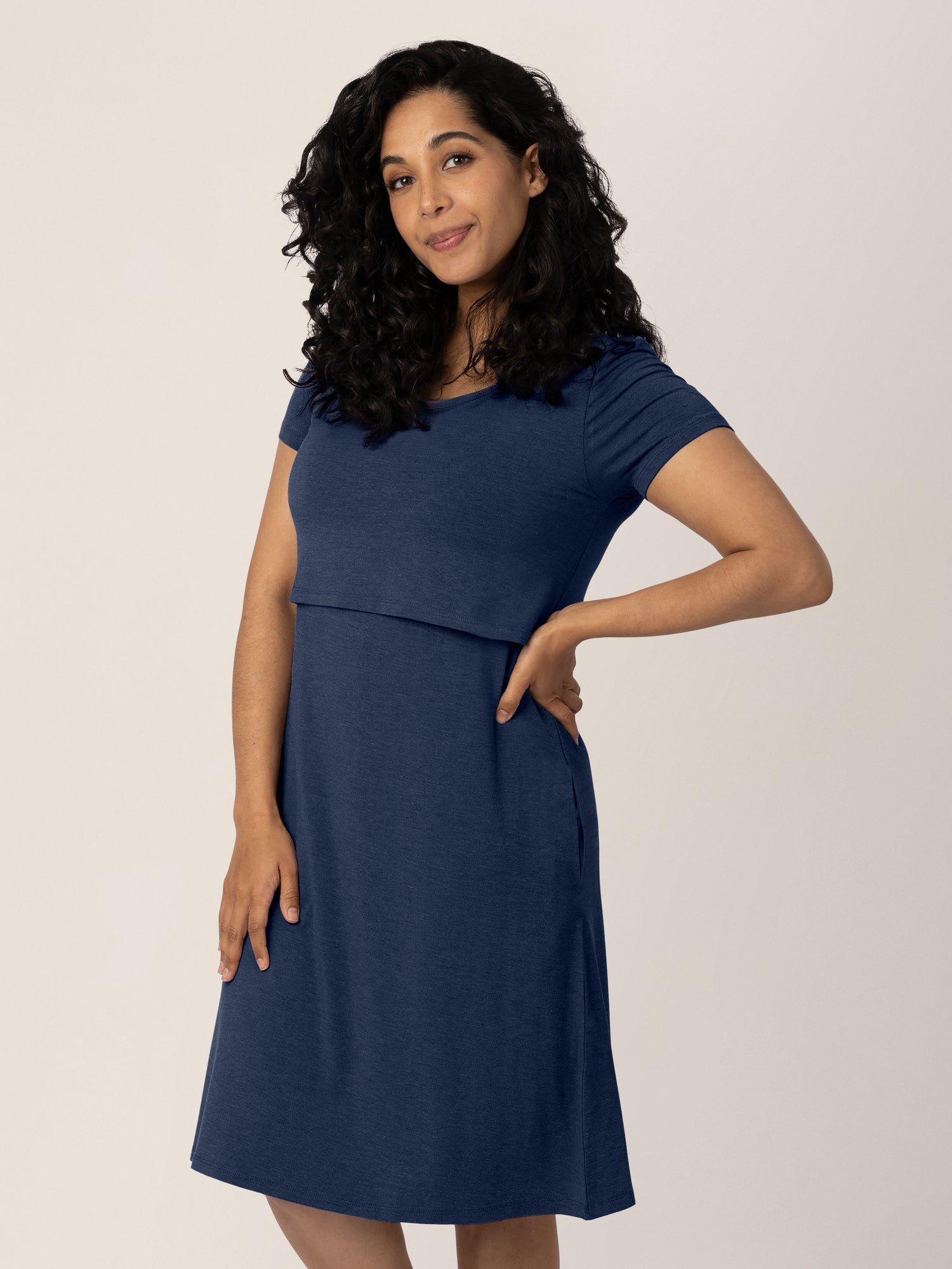 Model with her hand on her hip wearing the  Eleanora Bamboo Maternity & Nursing Dress in Navy Heather. 
