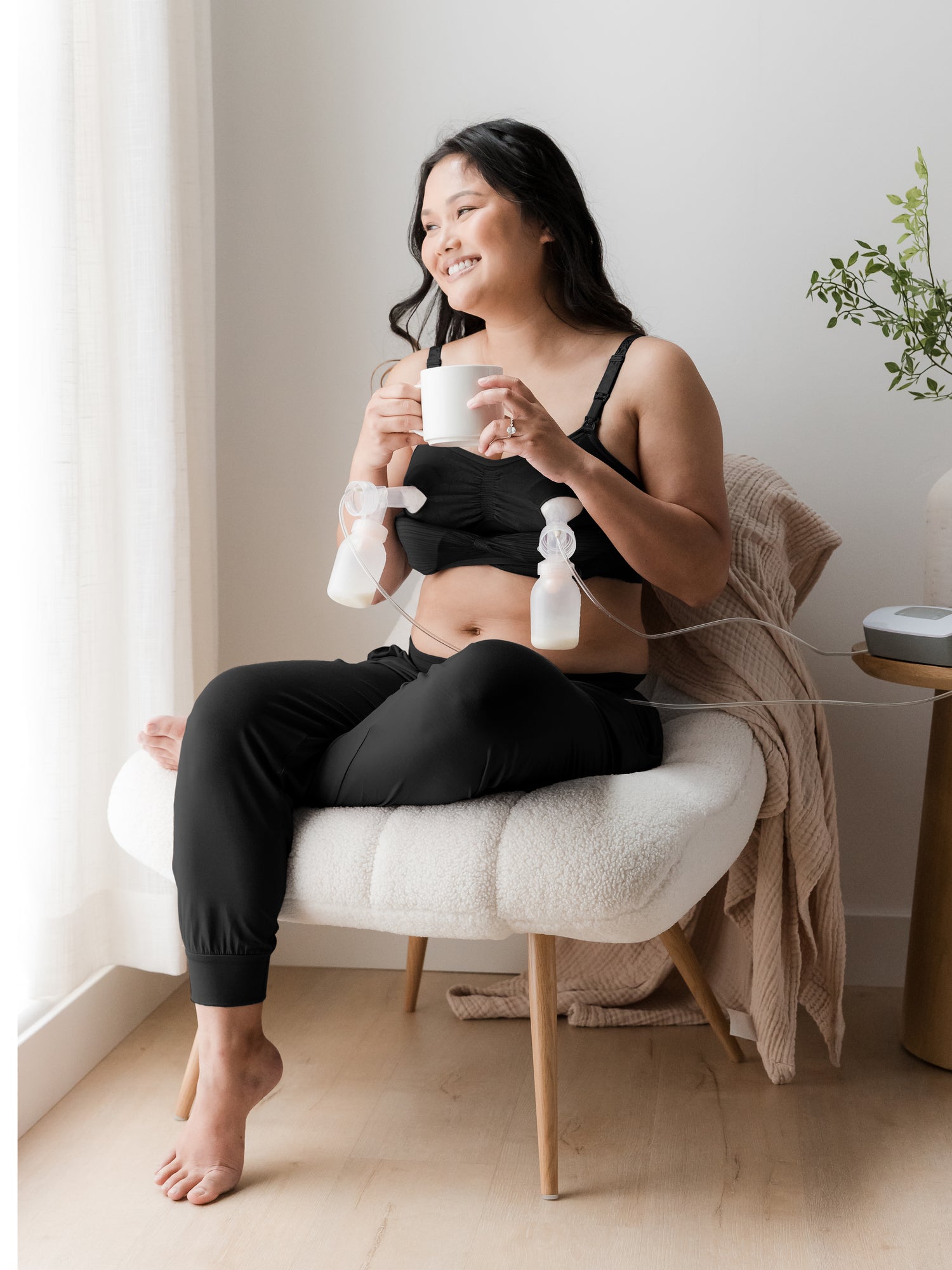 Pumping model wearing the Everyday Lounge Jogger in Black, sitting in a chair. 