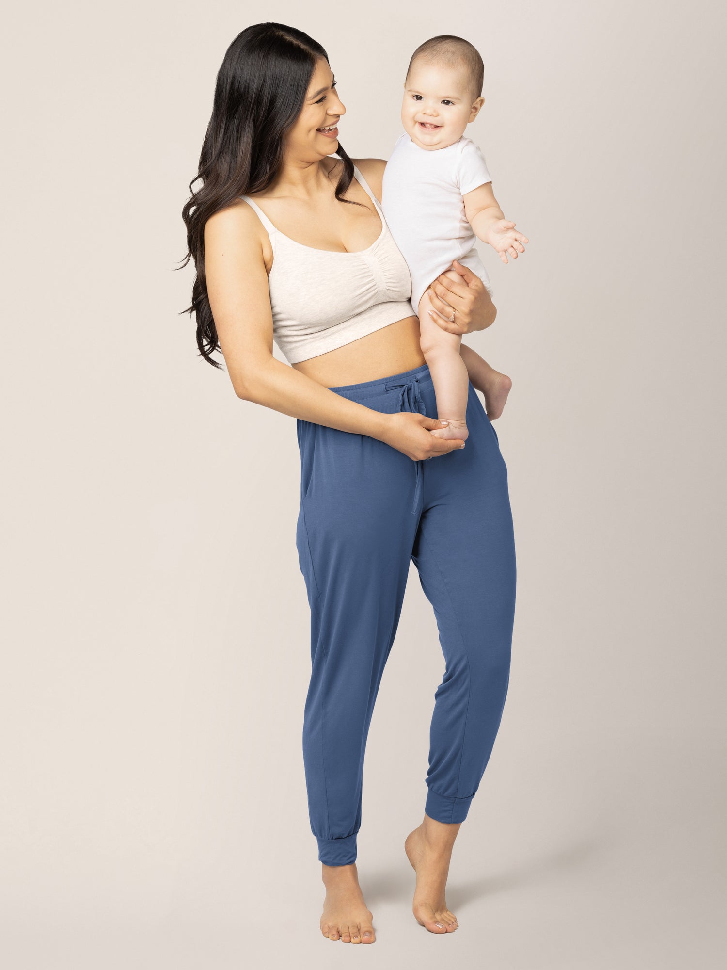 Model holding her baby while wearing the Everyday Lounge Jogger in Slate Blue