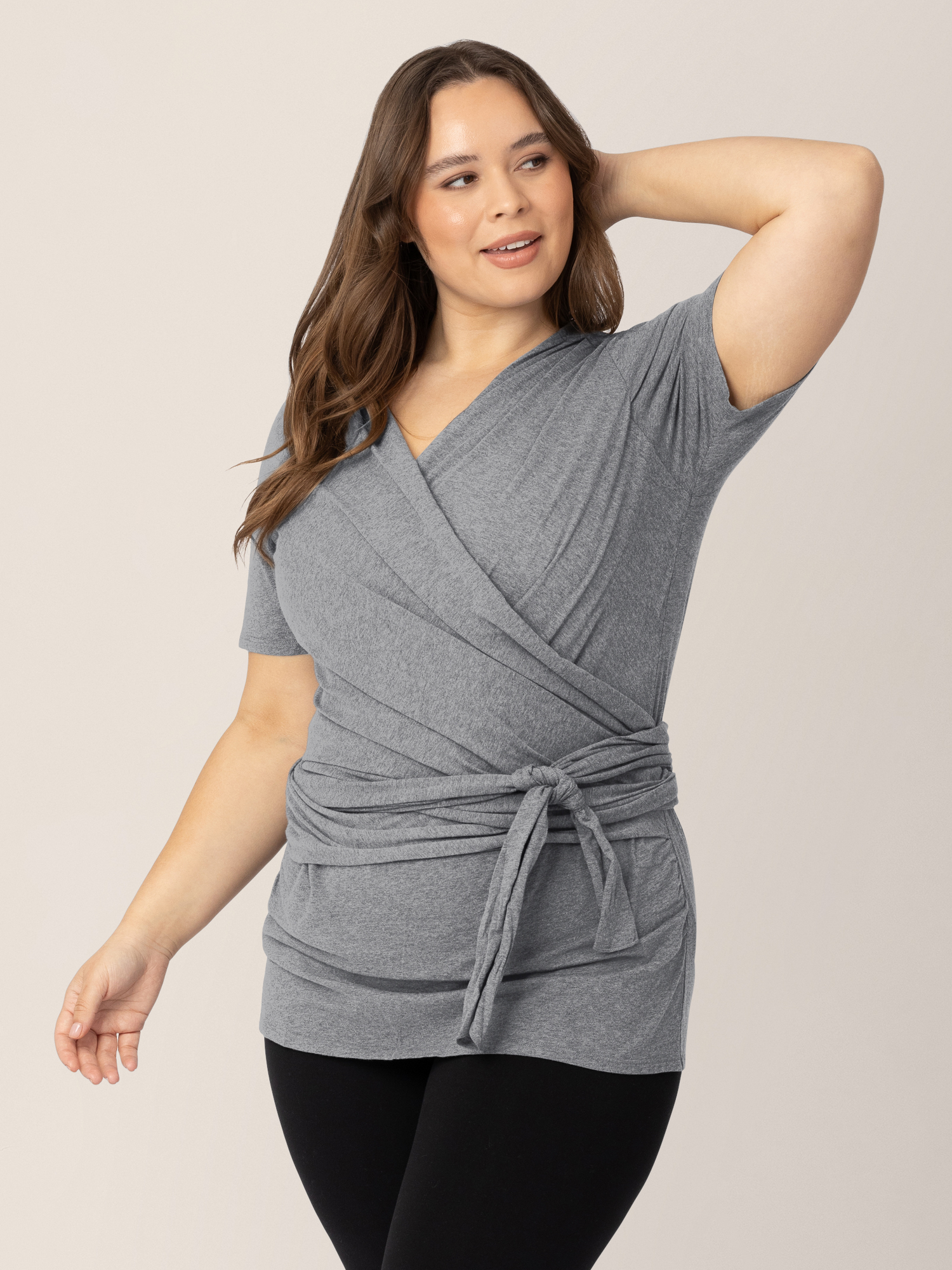 Model wearing the Organic Cotton Skin to Skin Wrap Top in Charcoal Grey Heather with her hand on the back of her head. 