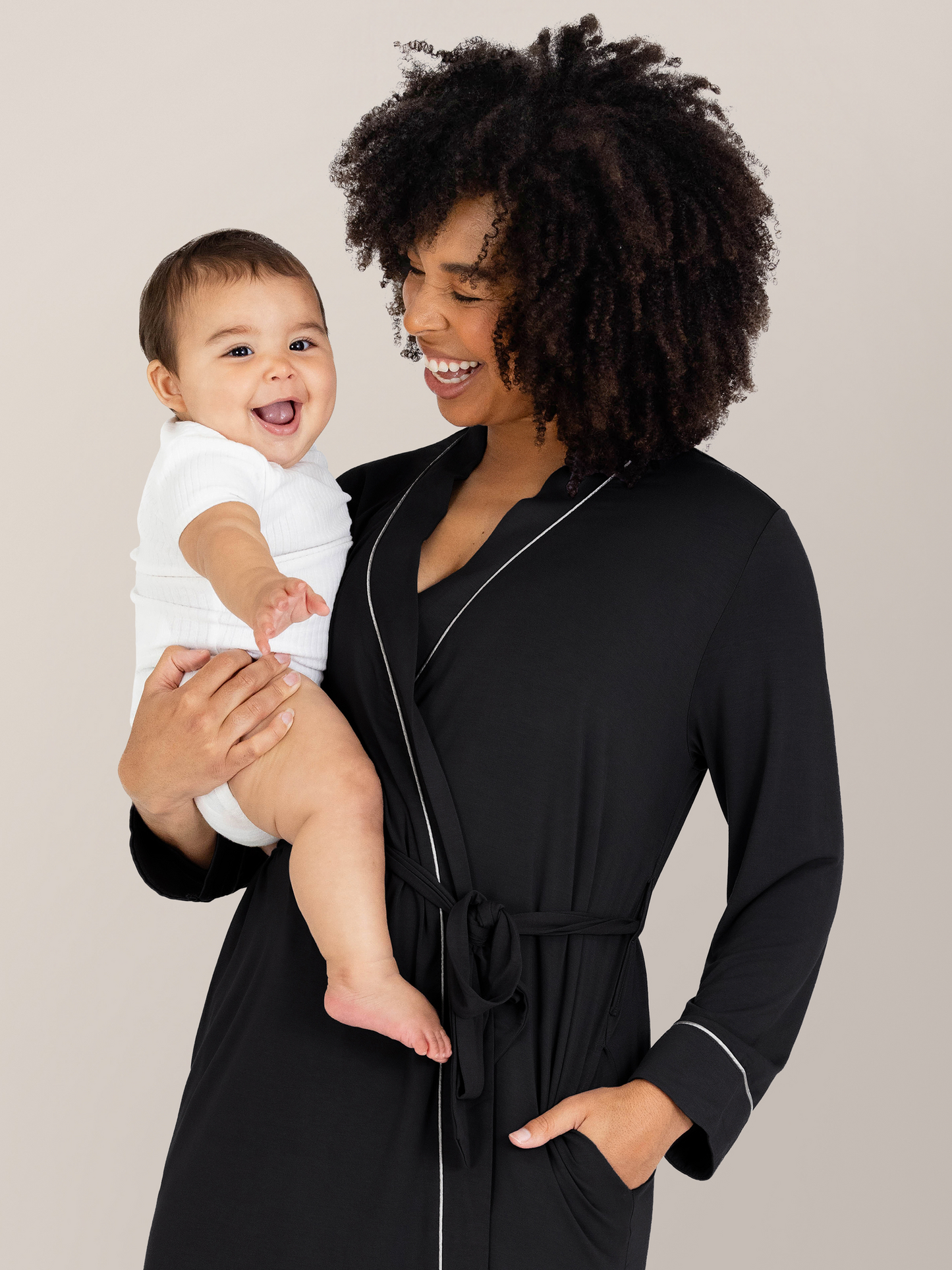 Model holding her baby while wearing the Clea Bamboo Robe in Black.