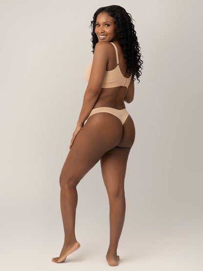 Back of a model wearing the Grow with Me™ Maternity & Postpartum Thong in Beige with her hand on her hip. 