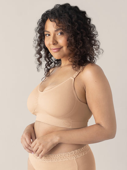 Model wearing the Nellie Sublime® Wireless Bra in Beige with her hands near her stomach. 