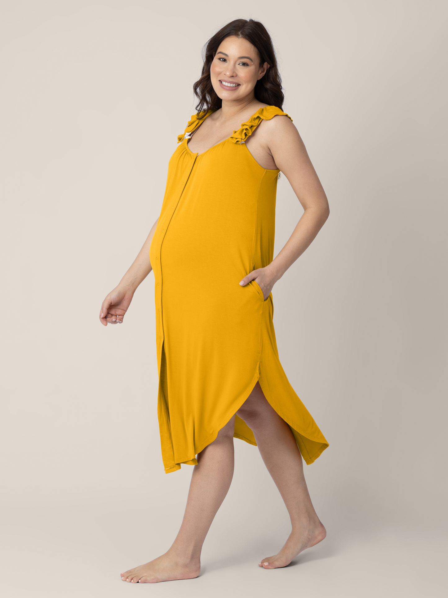 Side view of a pregnant model wearing the Ruffle Strap Labor & Delivery Gown in Honey