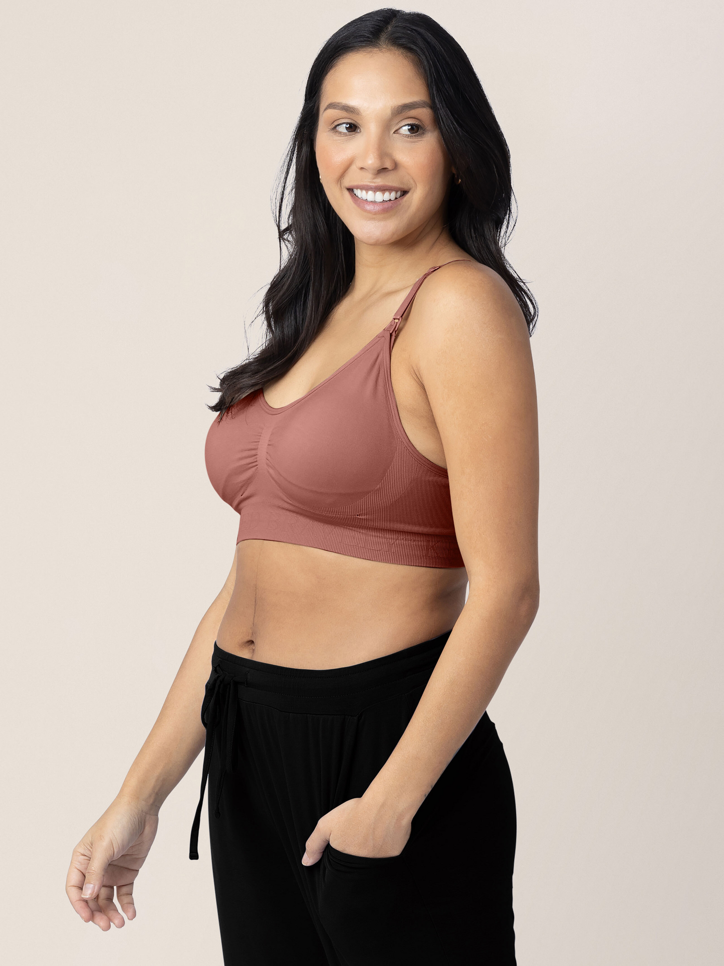 Side view of a model wearing the Simply Sublime® Nursing Bra in Redwood with her hand in her pocket.