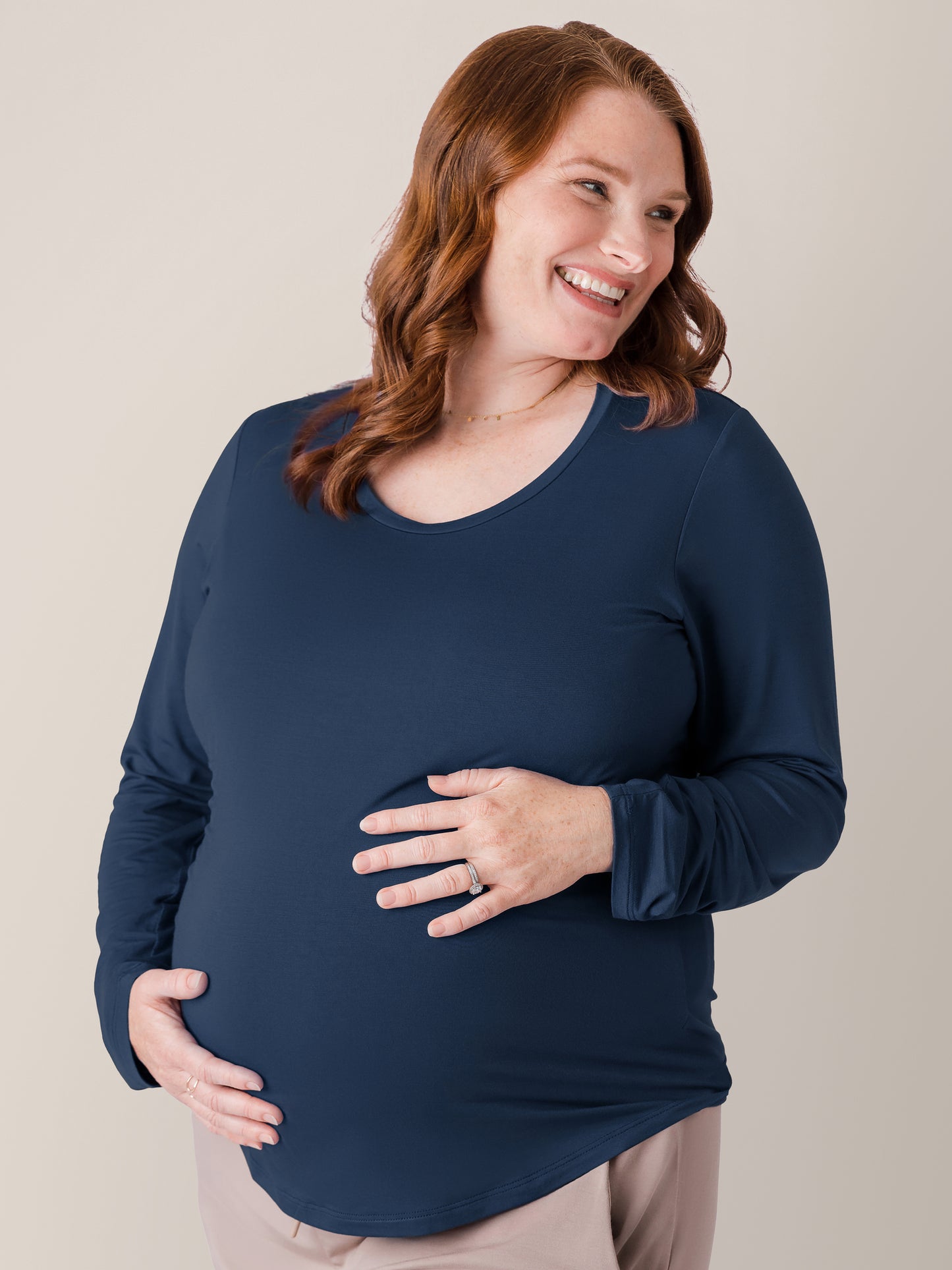 Pregnant model holding her stomach while wearing the Bamboo Maternity & Nursing Long Sleeve T-shirt in Navy 