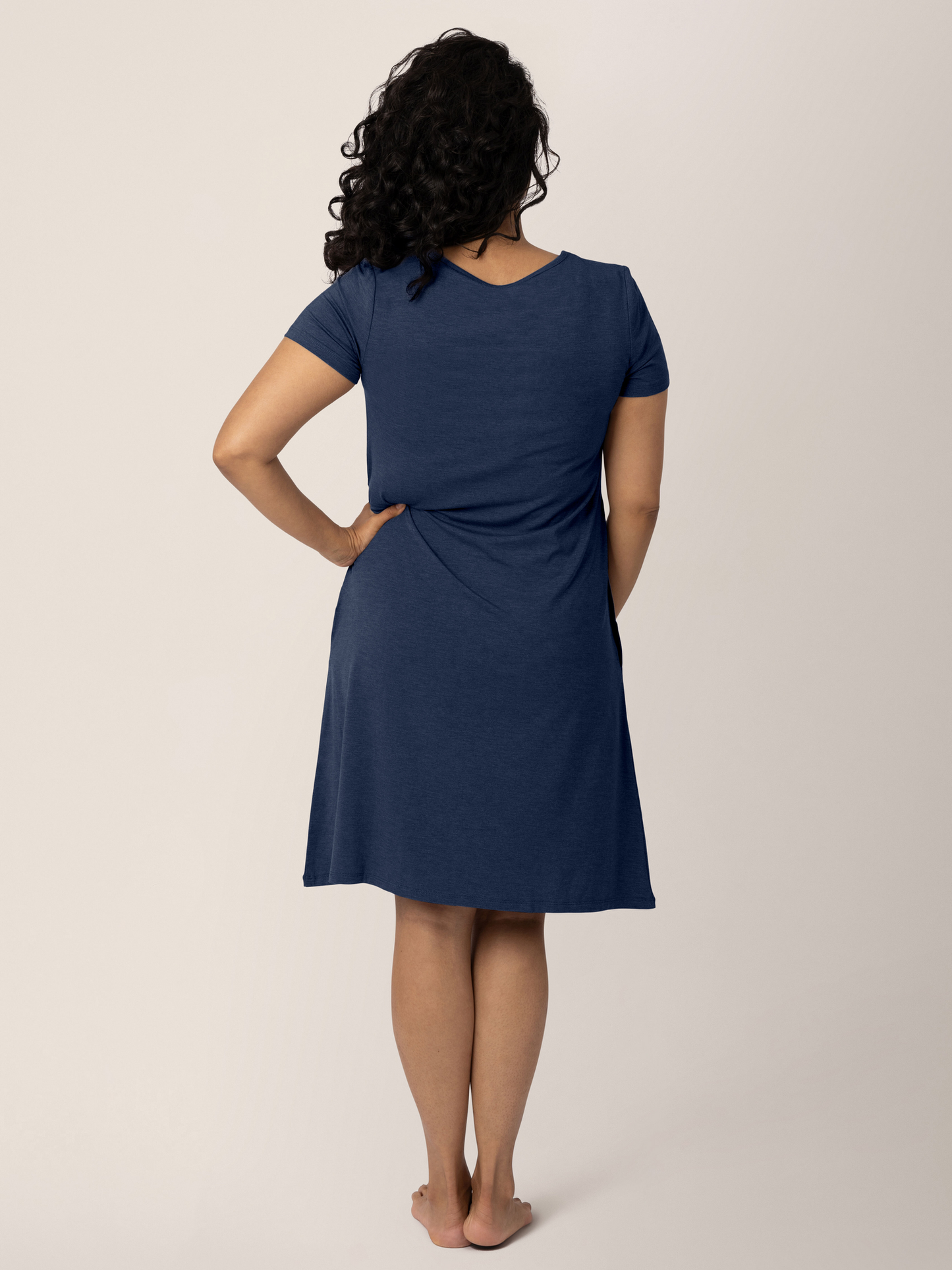 Back view of a model wearing the  Eleanora Bamboo Maternity & Nursing Dress in Navy Heather. 
