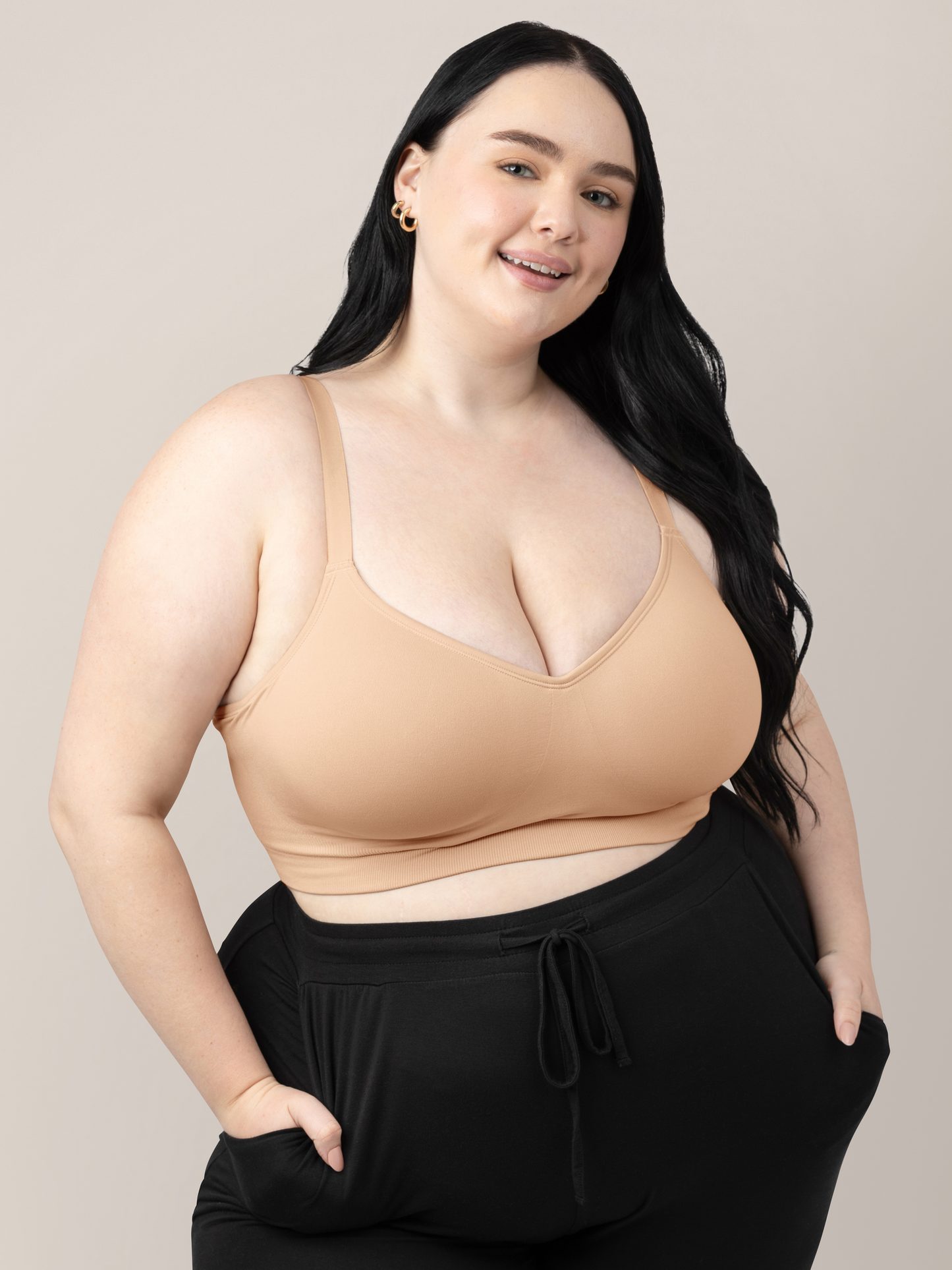 Busty model wearing the Everly Wireless Contour Bra  in Beige with her hands in her pockets. @model_info:Kenna is wearing a 2X Busty.