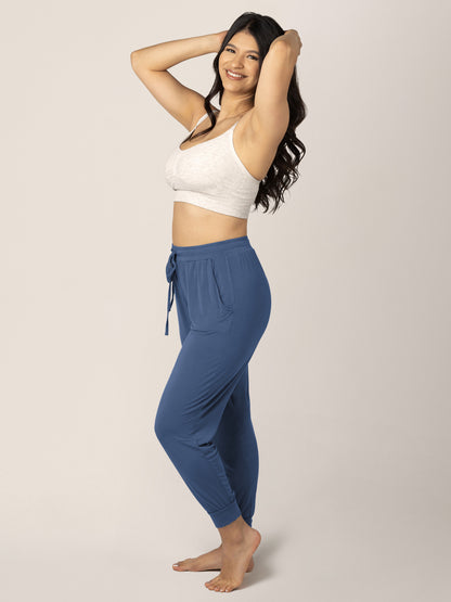 Model with her hands in her hair wearing the Everyday Lounge Jogger in Slate Blue @model_info:Nohely is 5'4" and wearing a Medium Regular.