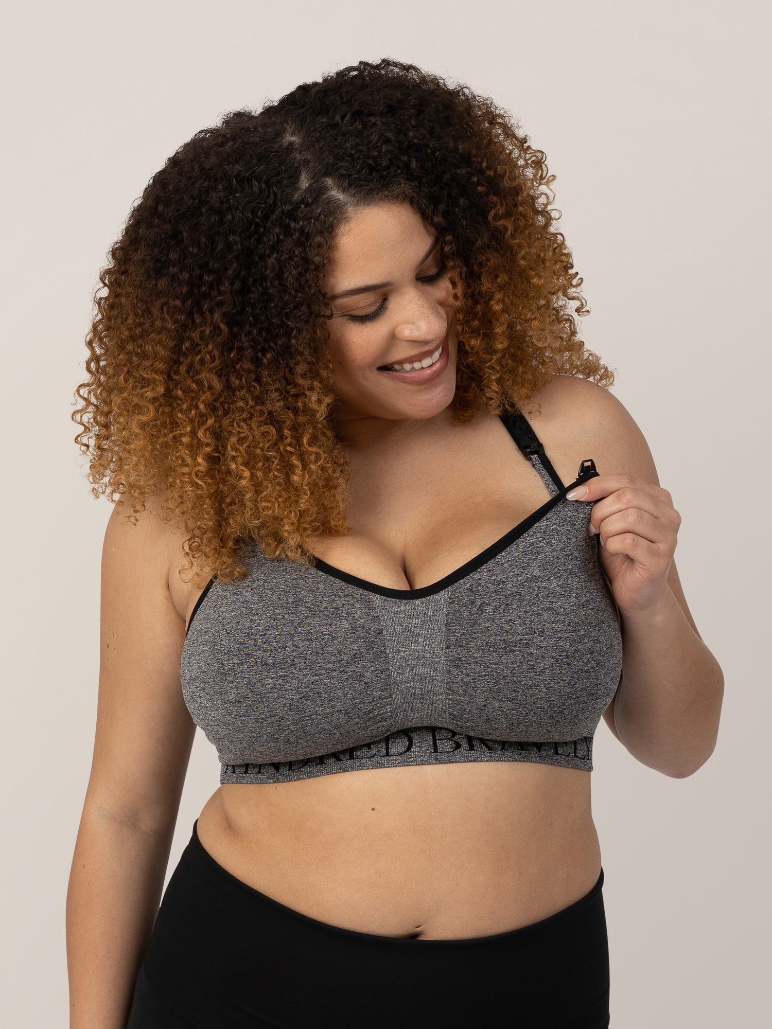 Model wearing the Sublime® Nursing Sports Bra in Heather Grey showing off the easy clip down nursing access.