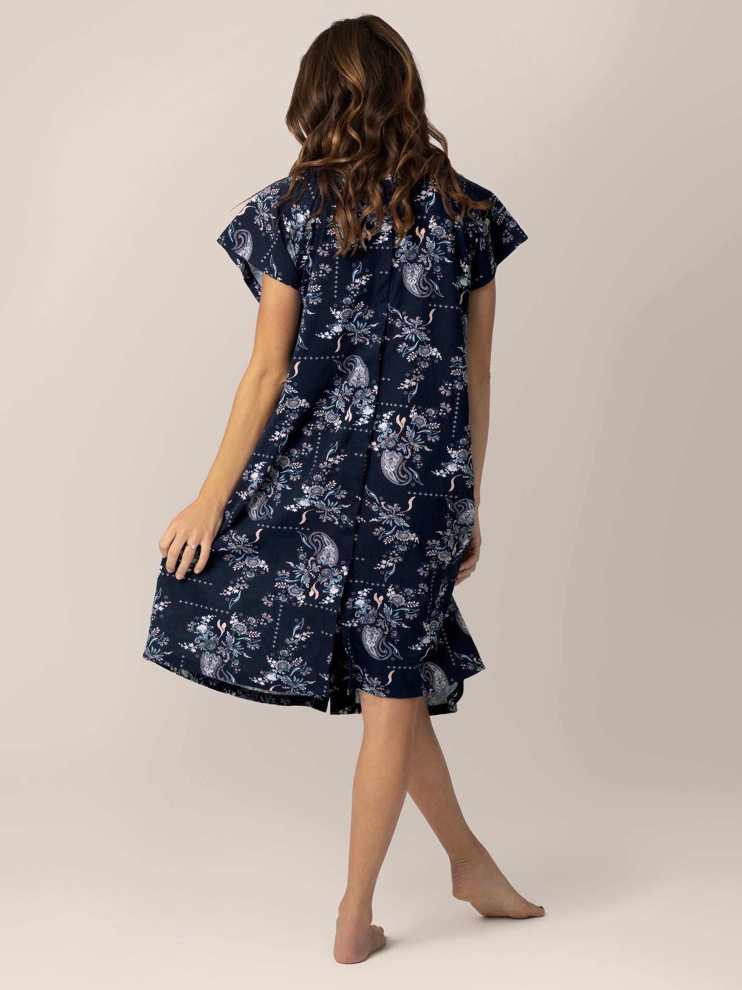 Back view of pregnant model wearing the Universal Labor & Delivery Gown in Navy Paisley.