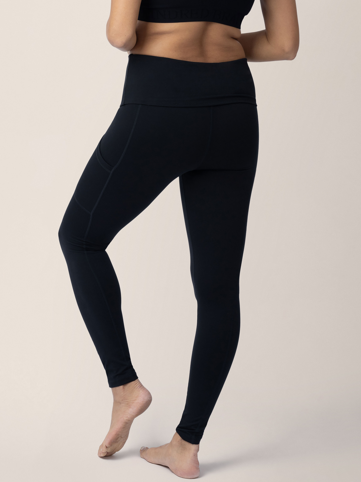 Back of a model wearing the Louisa Maternity & Postpartum Legging in Black with pockets.