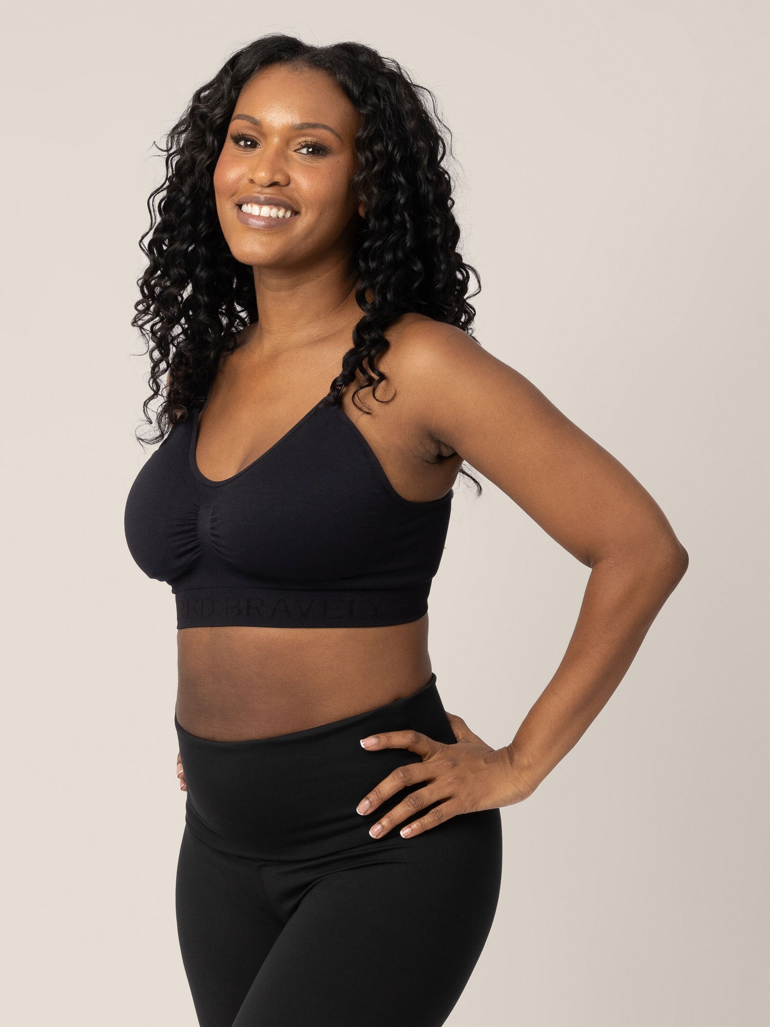 Model wearing the Sublime® Nursing Sports Bra in Black with her hands on her hips. 