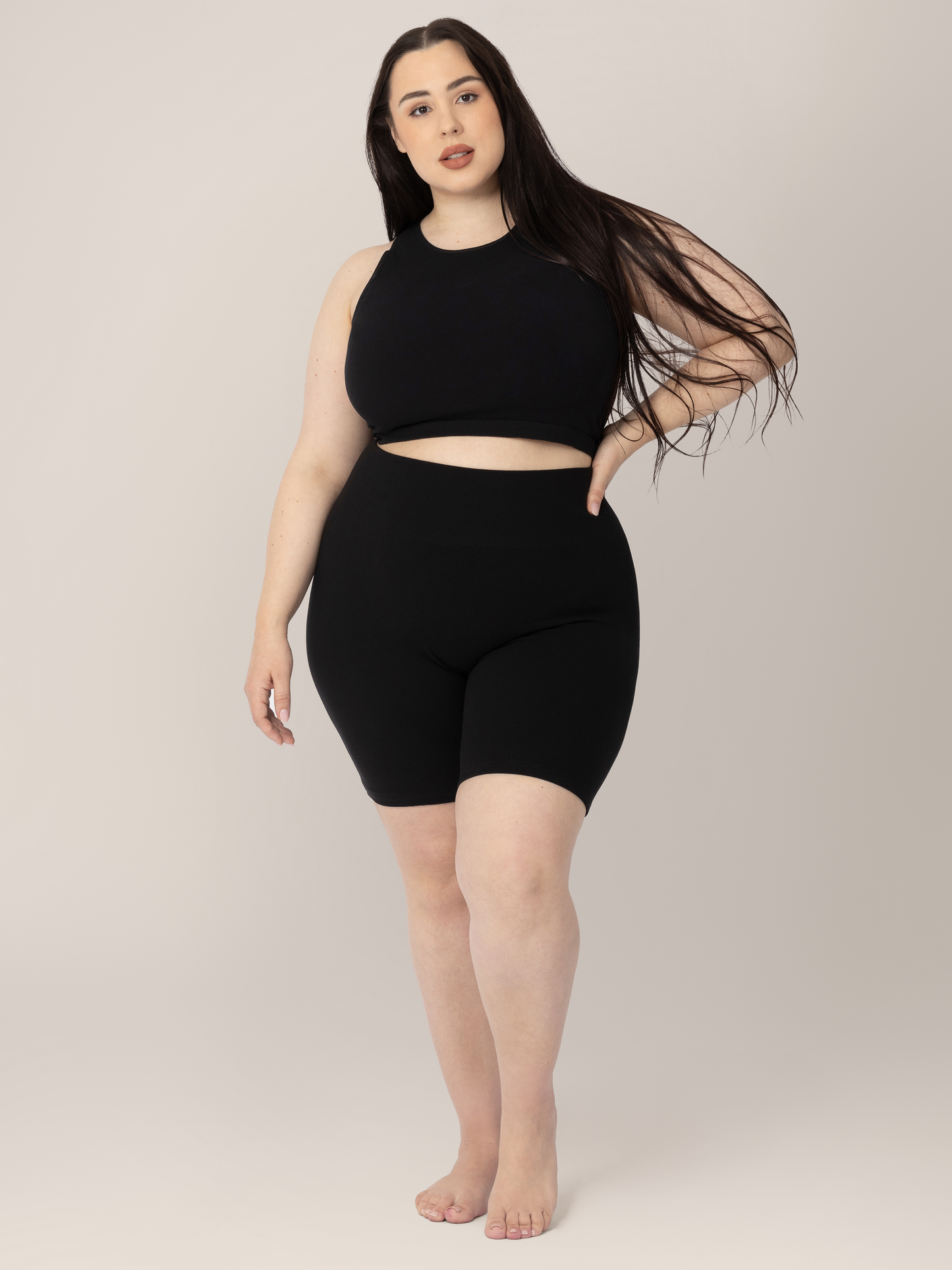 Front view of model wearing the Sublime® Bamboo Maternity & Postpartum Bike Short in Black with one hand on her hip, paired with the matching Sublime® Bamboo Maternity & Nursing Longline Bra. @model_info:Rachel is 5’6" and wearing a Large.