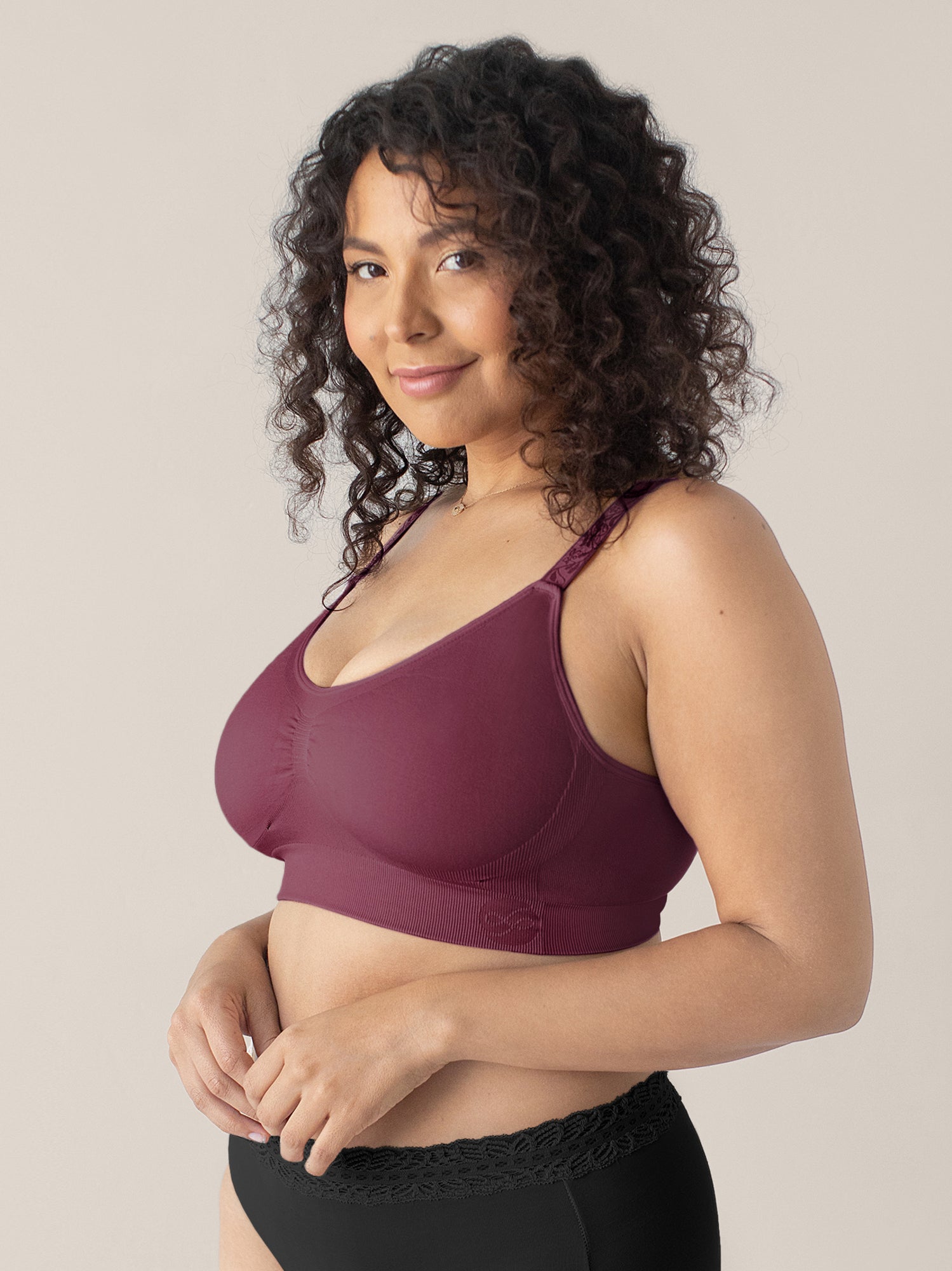 Model wearing the Nellie Sublime® Wireless Bra in Fig with her hands near her stomach. @model_info:Sierra is wearing a Medium Busty.