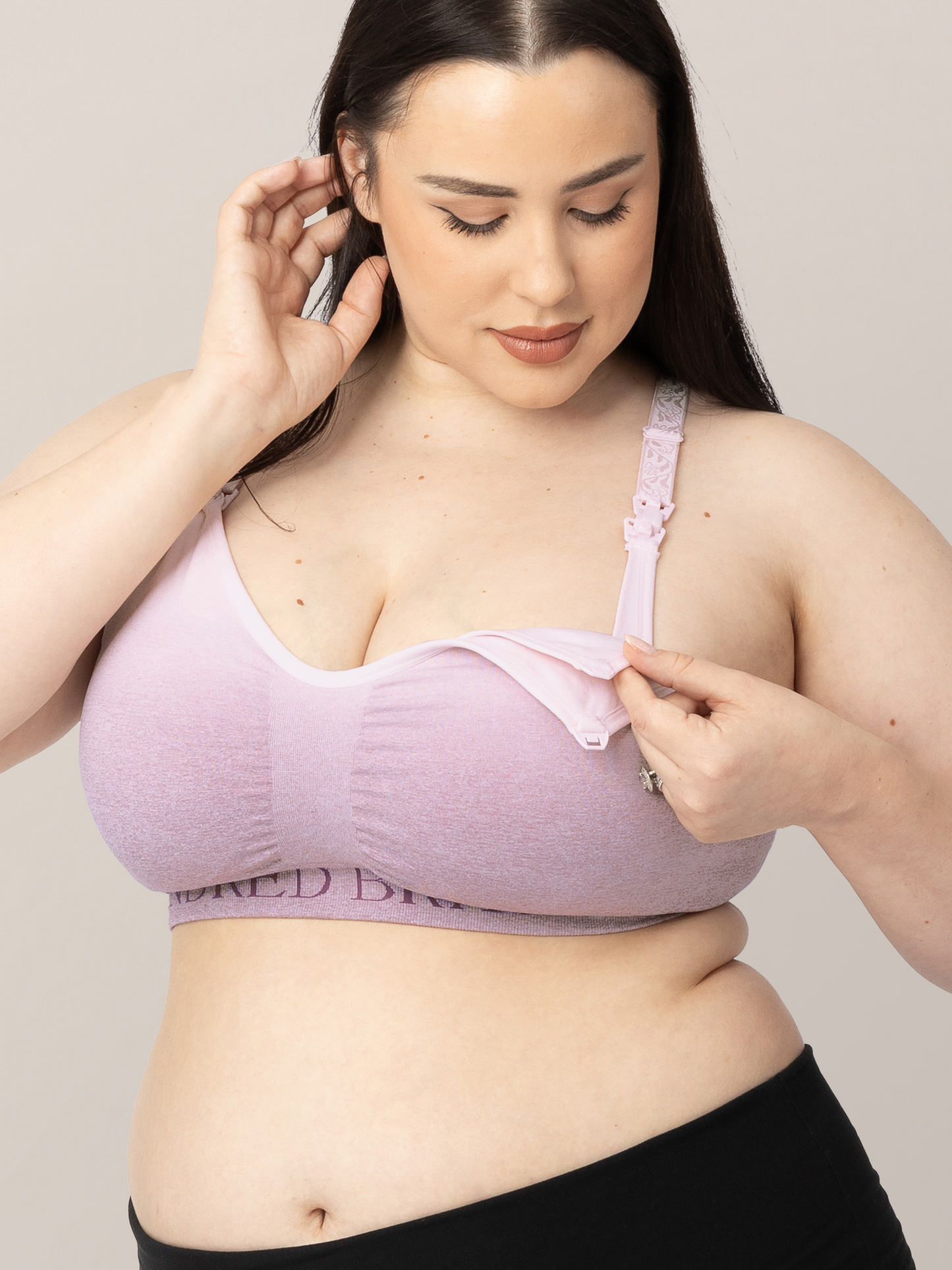 Model looking down at the easy clip down nursing panel on the Sublime® Hands-Free Pumping & Nursing Sports Bra in ombre purple. 