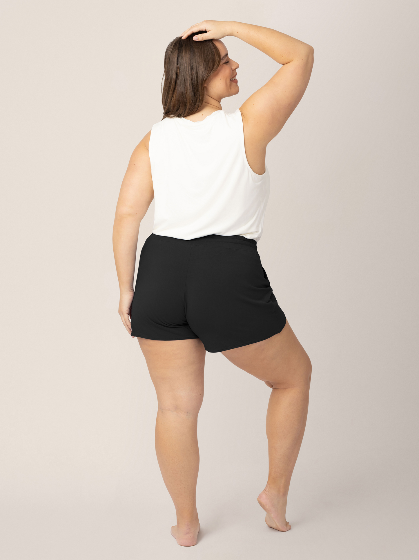 Back view of a model wearing the Bamboo Maternity & Postpartum Lounge Short in Black with a white tank top. @model_info:Venezia is wearing a 1X. 