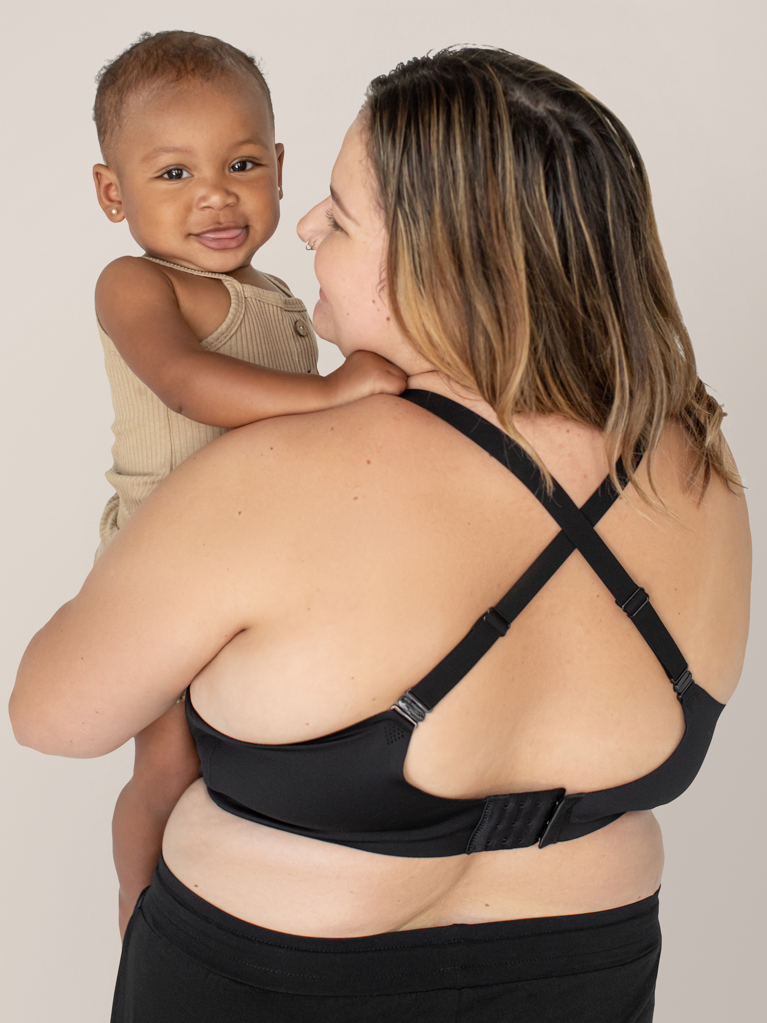 Model holding her baby while wearing the Ultra Comfort Smooth Classic Nursing Bra | Black