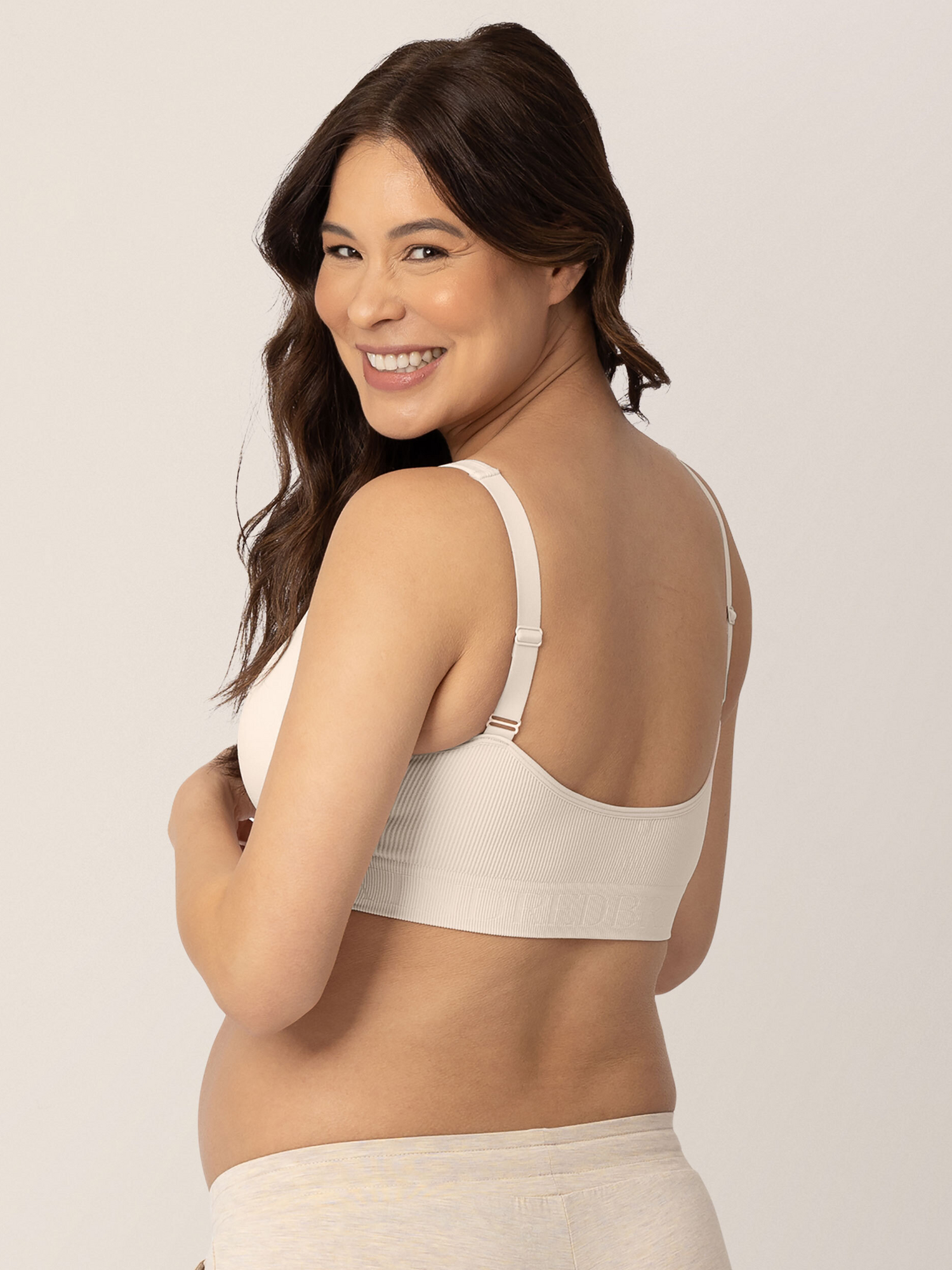 Back of a pregnant model wearing the Sublime® Adjustable Crossover Nursing & Lounge Bra in Stone