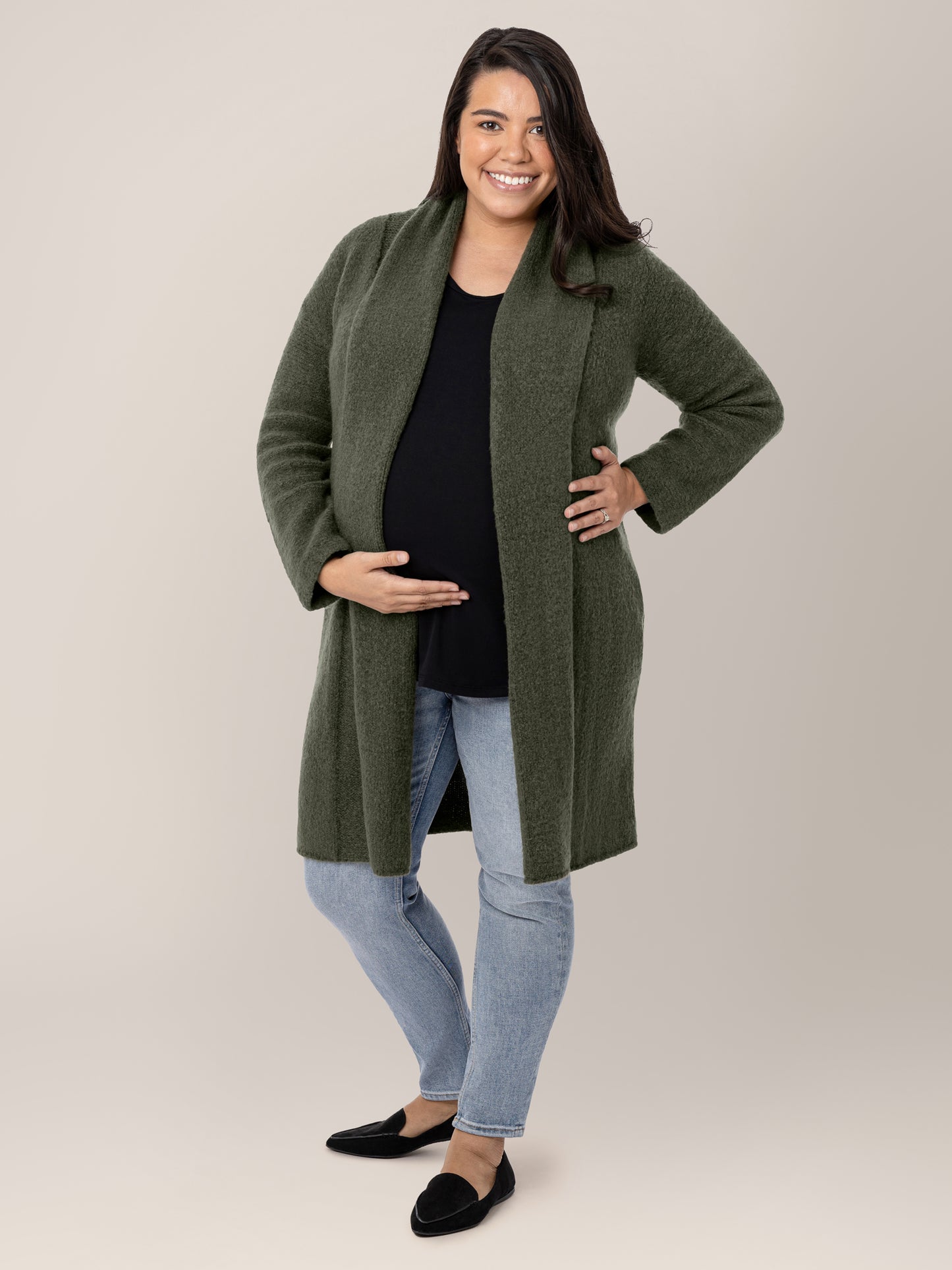 Model wearing the Chloe Cardigan Sweater in Thyme with her hand on her pregnant belly. @model_info:Frances is wearing a M/L.