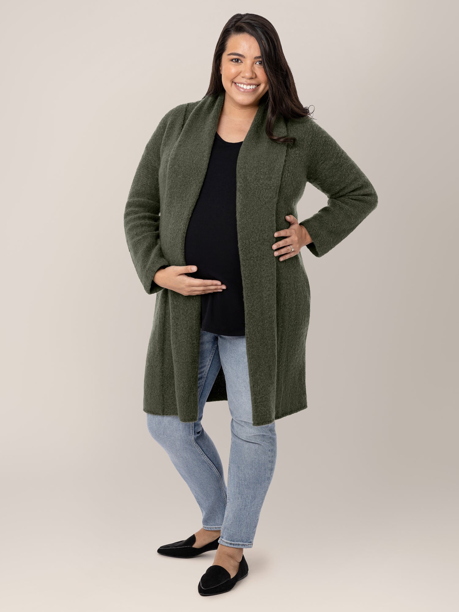 Model wearing the Chloe Cardigan Sweater in Thyme with her hand on her pregnant belly. @model_info:Frances is wearing a M/L.