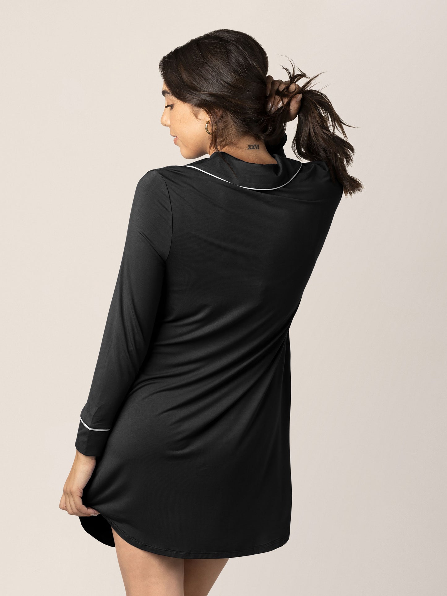 Back view of a model holding back her hair while wearing the Clea Bamboo Long Sleeve Sleep Shirt in Black