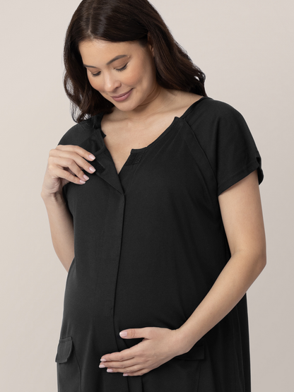 Model wearing the Universal Labor & Delivery Gown in Black looking down at her pregnant belly.