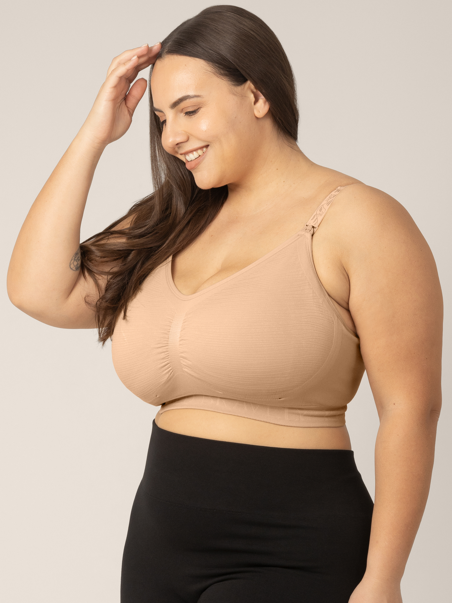 Side view of super busty model wearing the Sublime® Hands-Free Pumping & Nursing Bra in Beige.