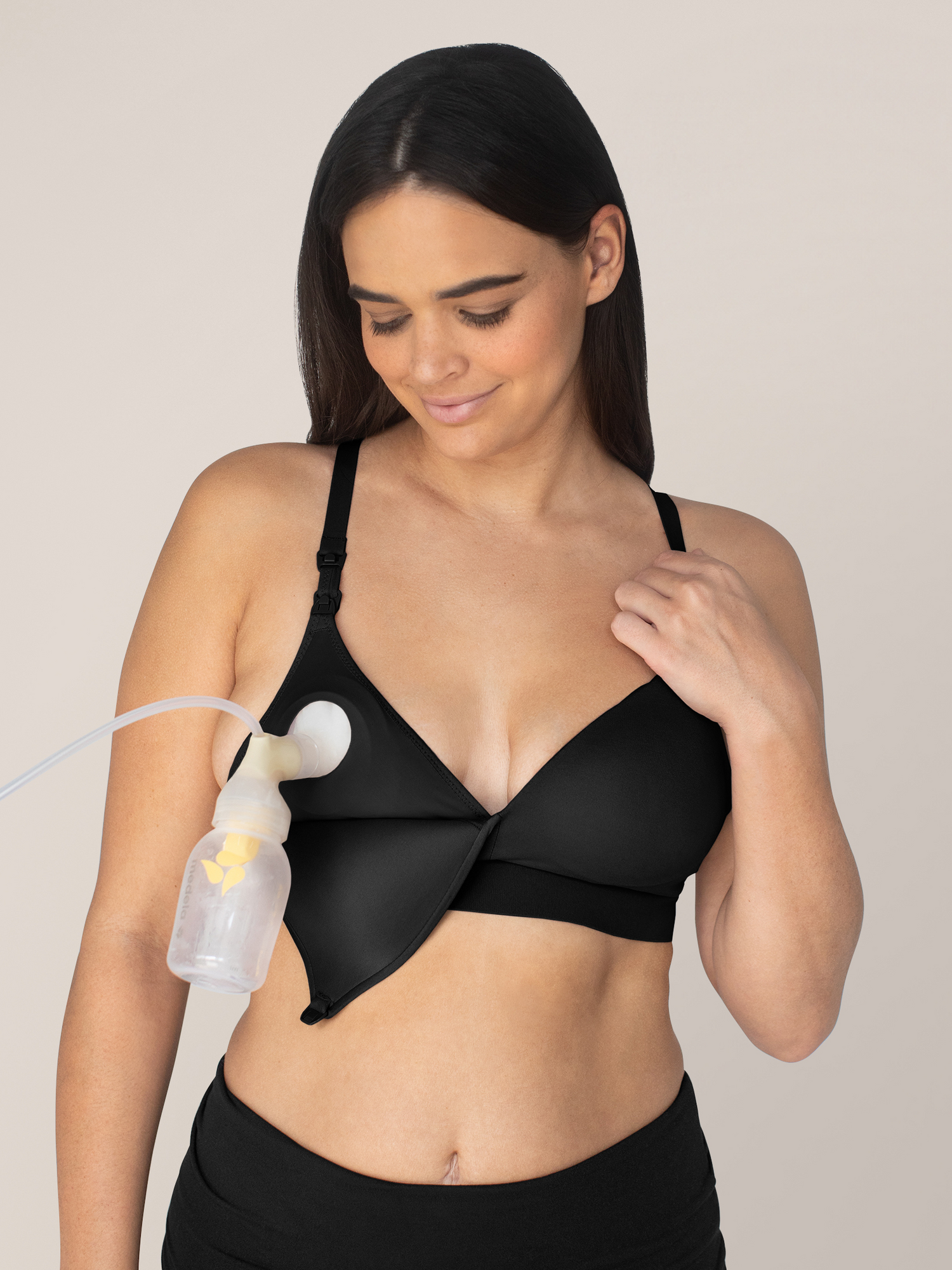 Model wearing the Minimalist Hands-Free Pumping & Nursing Bra in Black connected to a Pump.