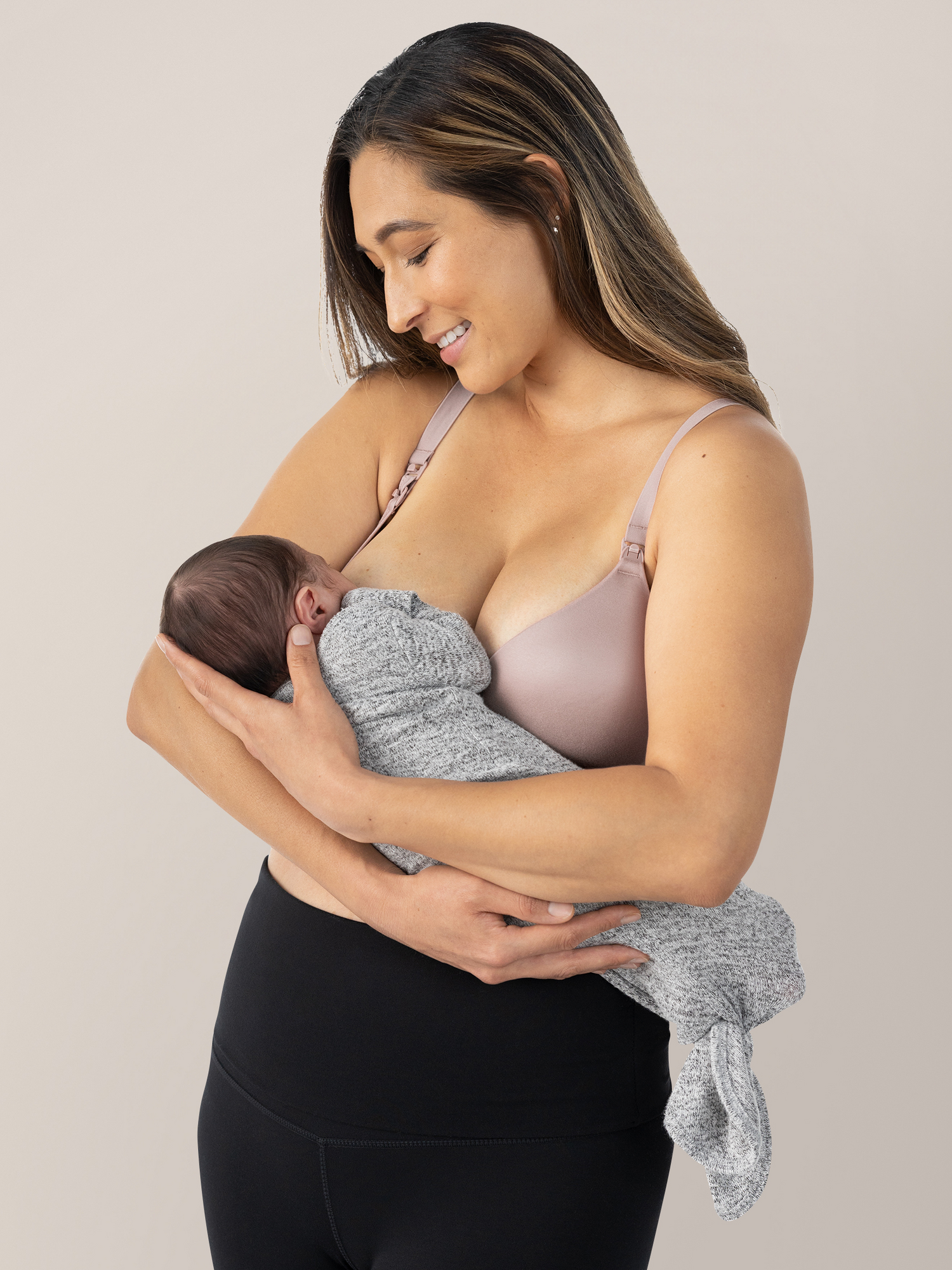 Model feeding her baby while wearing the  Minimalist Hands-Free Pumping & Nursing Bra in Lilac Stone@model_info:Joy is wearing a Small.