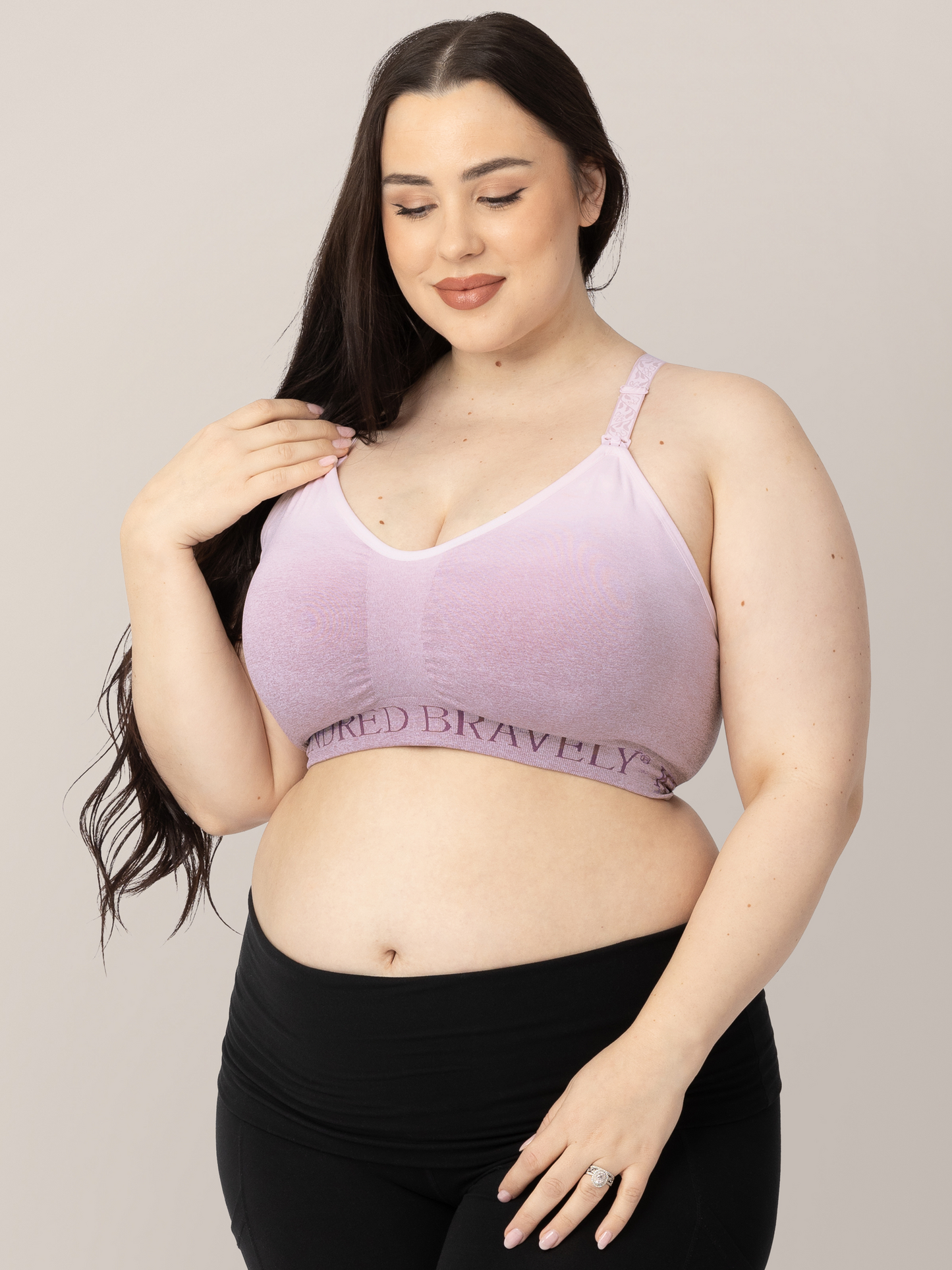 Model smiling while wearing teh Sublime® Hands-Free Pumping & Nursing Sports Bra in ombre purple.