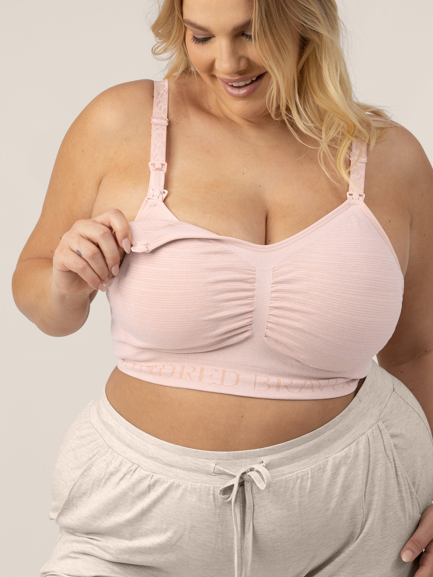 Busty model wearing the Sublime® Hands-Free Pumping & Nursing Bra in Pink Heather