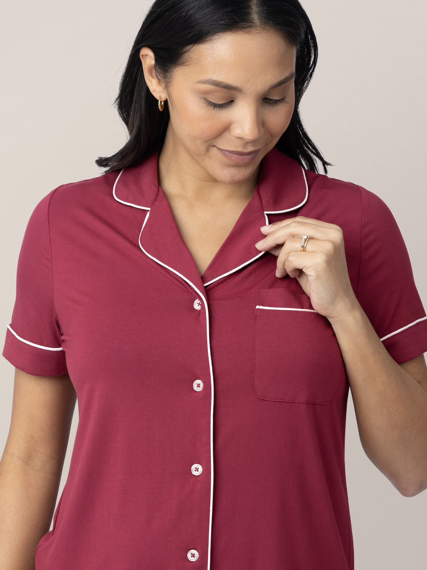 Closeup of the Clea Bamboo Short Sleeve Pajama Set in Deep Berry with the model's hand on the collar. 