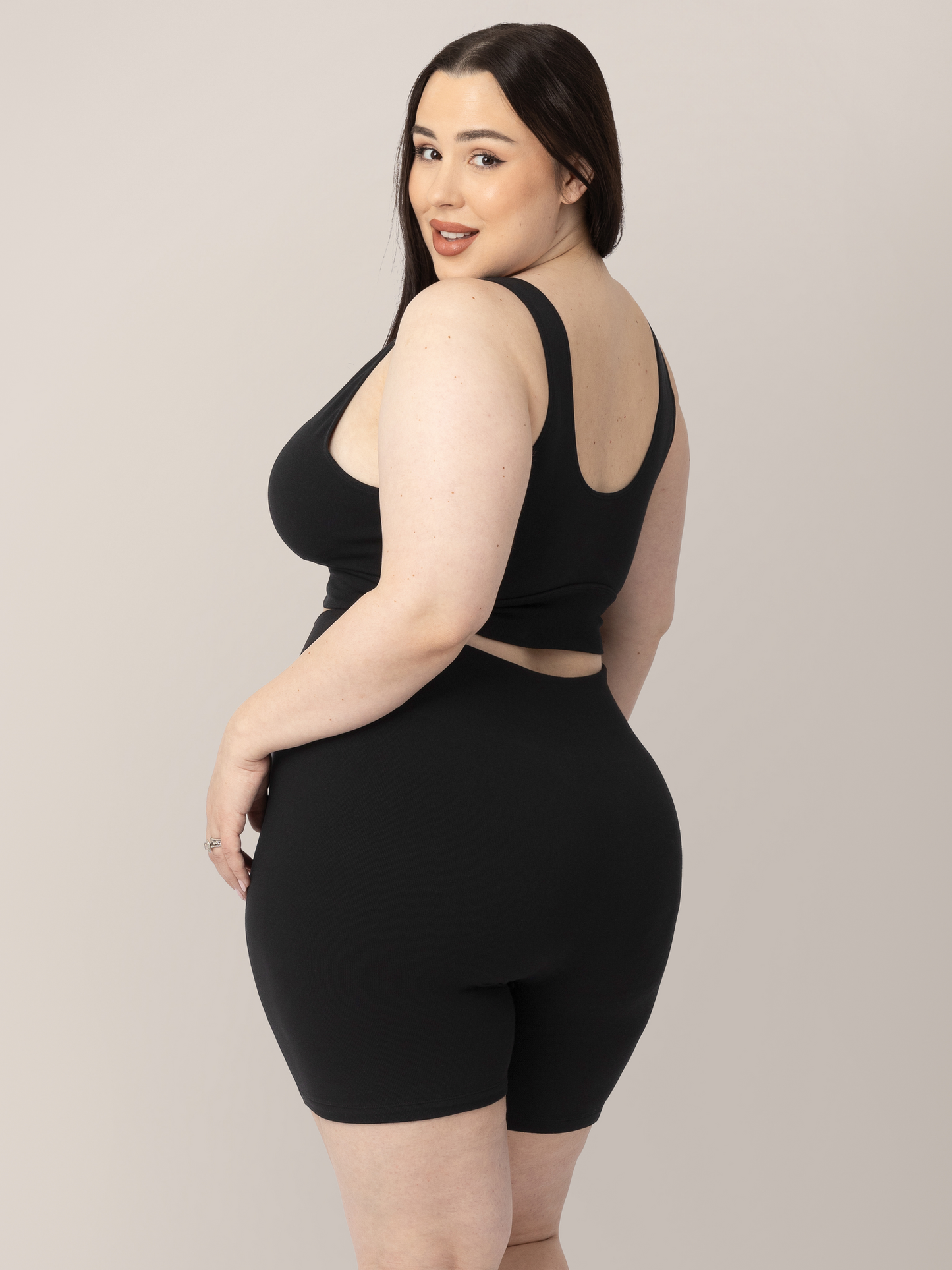 3/4 back view of model wearing the Sublime® Bamboo Maternity & Postpartum Bike Short in Black, paired with the matching Sublime® Bamboo Maternity & Nursing Plunge Bra.