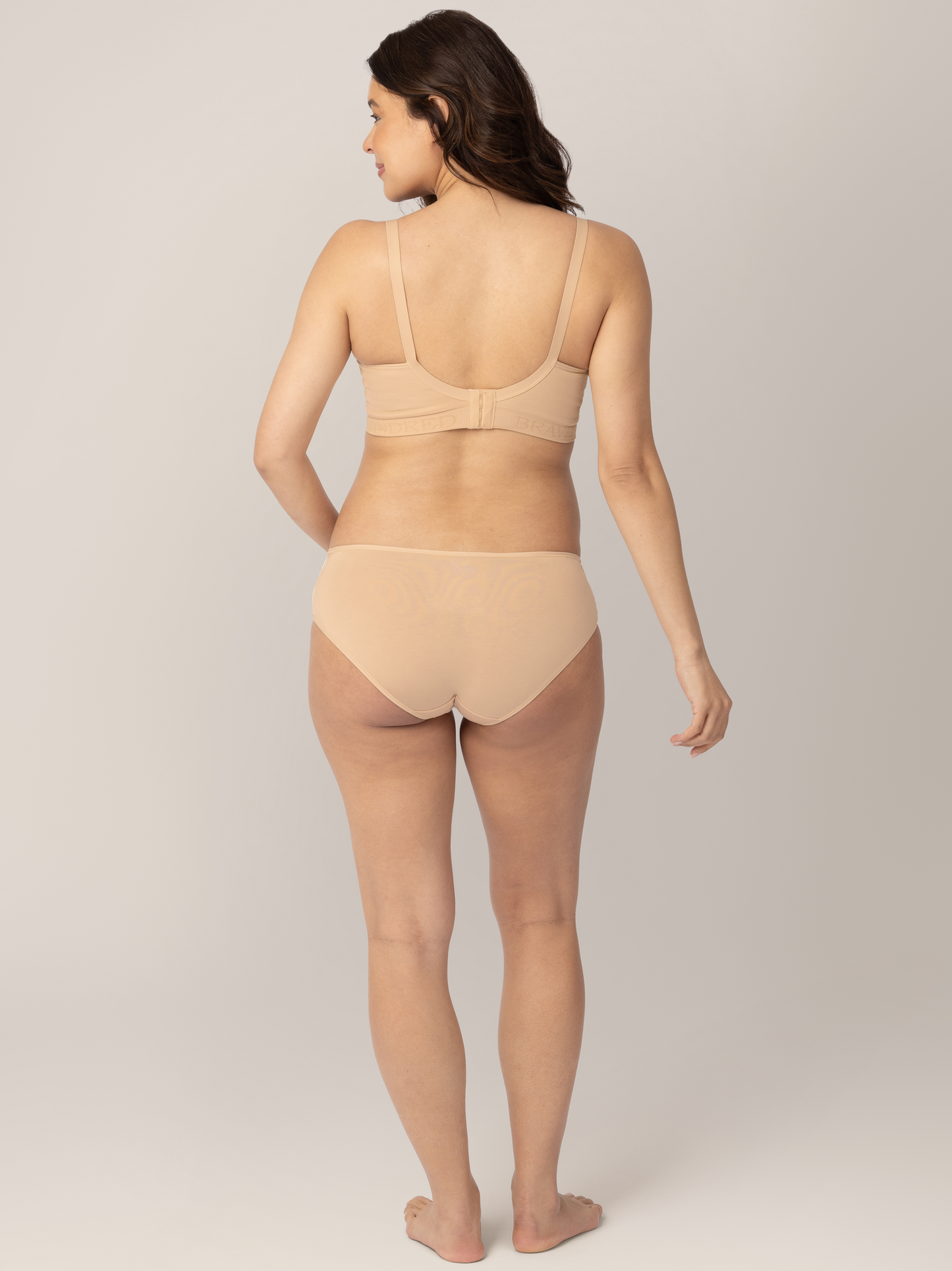 Back view of a pregnant model wearing the Under-the-Bump Bikini Underwear in Neutrals